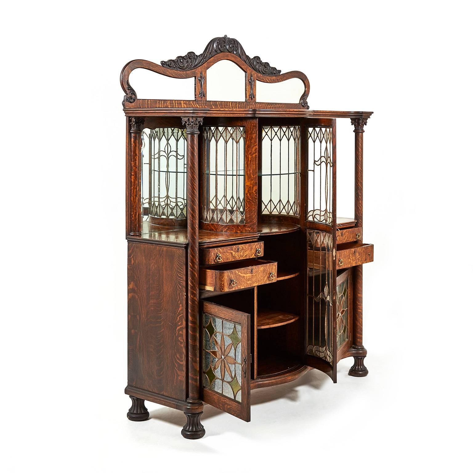 An outstanding expression of late-Victorian ‘Americana’, this buffet presents an explosion of Art Nouveau-style stained and leaded glass, corinthian columns, and bold ‘tiger’ oak, capped by a carved and bevelled mirror, circa 1890.

 