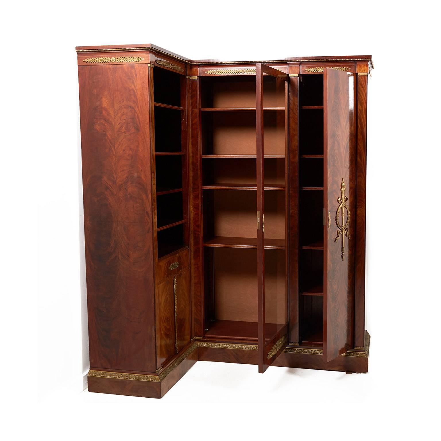 French Mahogany Empire-revival corner cabinet with gilt bronze mounts and striking accents, circa 1910. With glass doors and finished shelves, this is a beautiful and unusual corner piece. Plenty of storage, too.


           