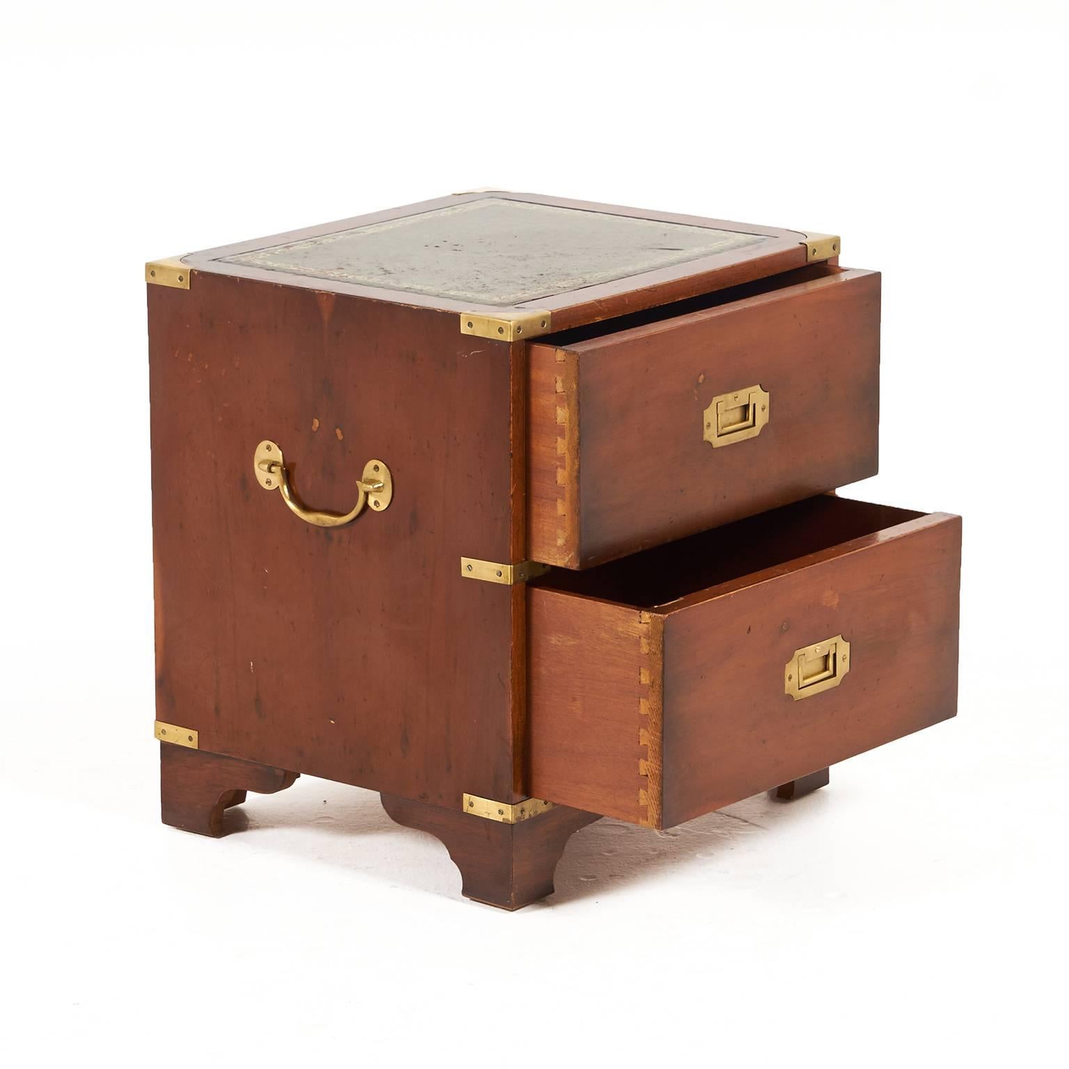 Midcentury small nightstand/chest, French campaign style – with two drawers. Decorative and distinctive, with a leather inset top and brass accents. Small enough to be useful in many rooms throughout the home.




