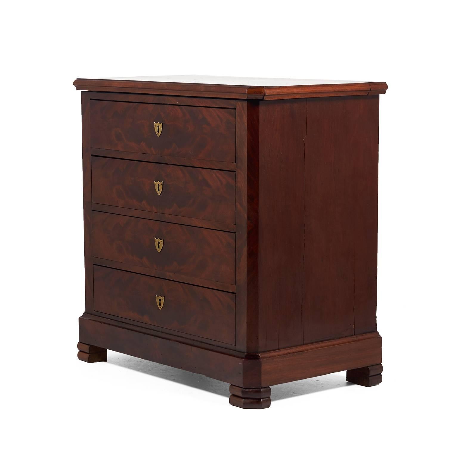 An unusually-small, French flame mahogany four-drawer chest, or commode, with beautiful brass plate shield escutcheons, circa 1870.



