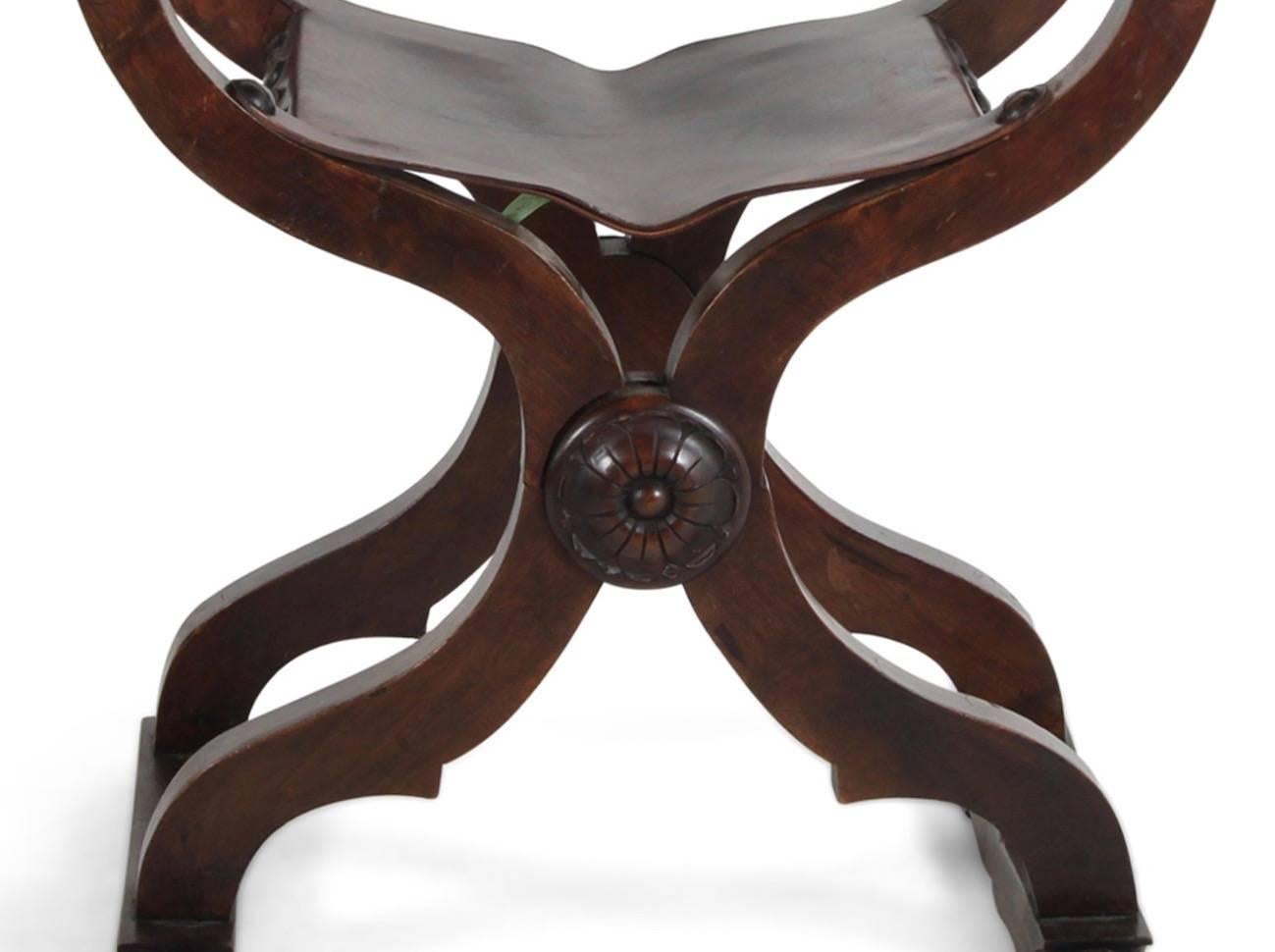 An Italian walnut Savonarola chair with carved details and leather seat and back, circa 1930.


     
    
