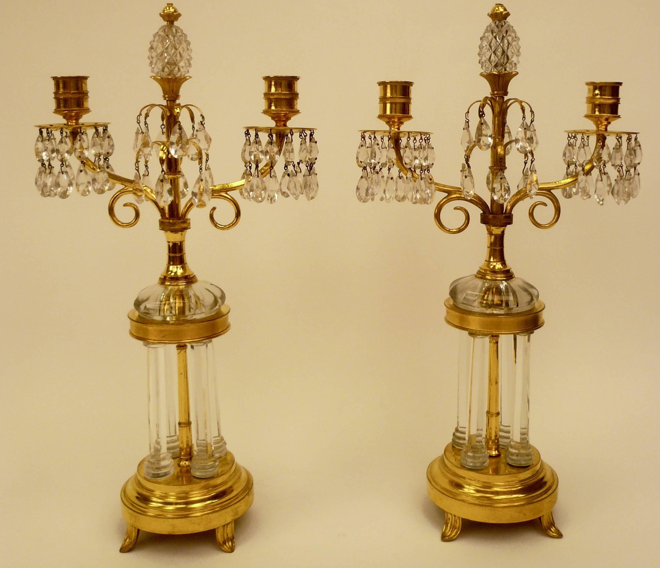 Cette paire de candélabres avec des bases en forme de temples de jardin miniatures est attribuée à William Parker et date de 1800. Parker a fourni des lustres au Prince de Galles pour Carlton House. Voir Martin Mortimer ; The English glass
