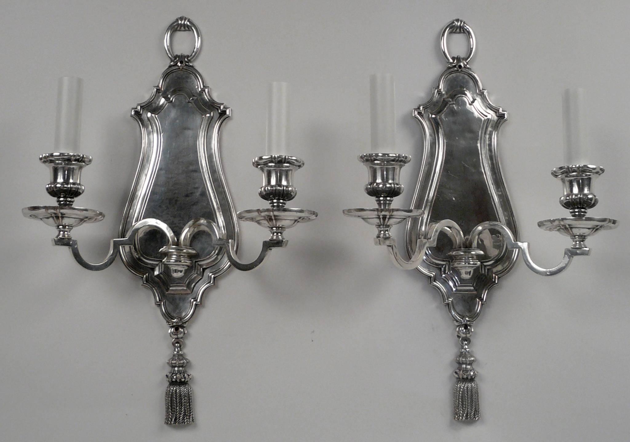 This pair of silver plated sconces by Edward F. Caldwell are finely detailed, and feature tassels, and loop-form finials.