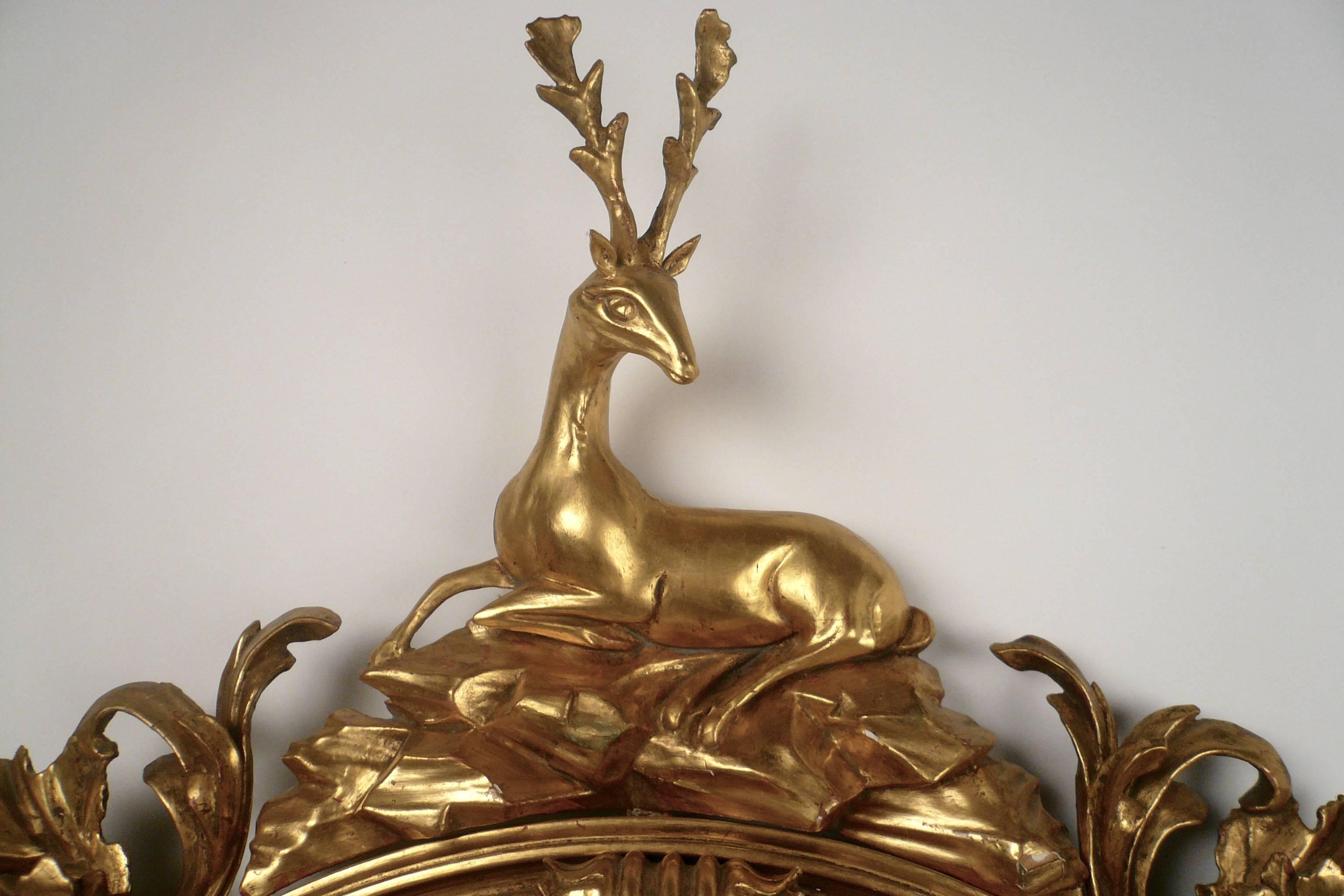This fine early 19th century carved and gilded girandole mirror still retains Thomas Fentham's trade label. Affixed with candle arms ending in gilt-metal nozzles, the mirror is surmounted by a stag seated upon rockery. 
Examples of Fentham's work