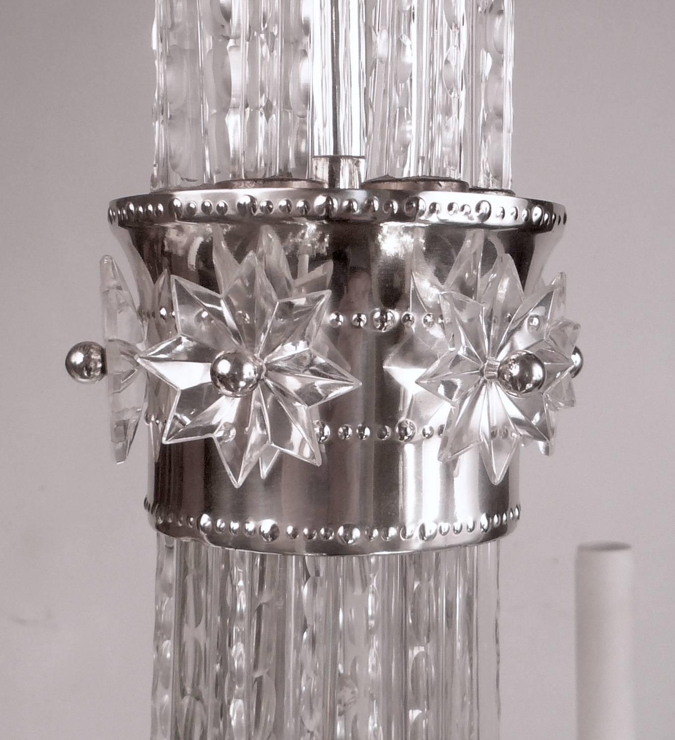 This stylish six-light Hollywood Regency chandelier has an Art Deco influenced crystal star mounted silver collar. The crystal is first quality, and finely cut throughout.

         