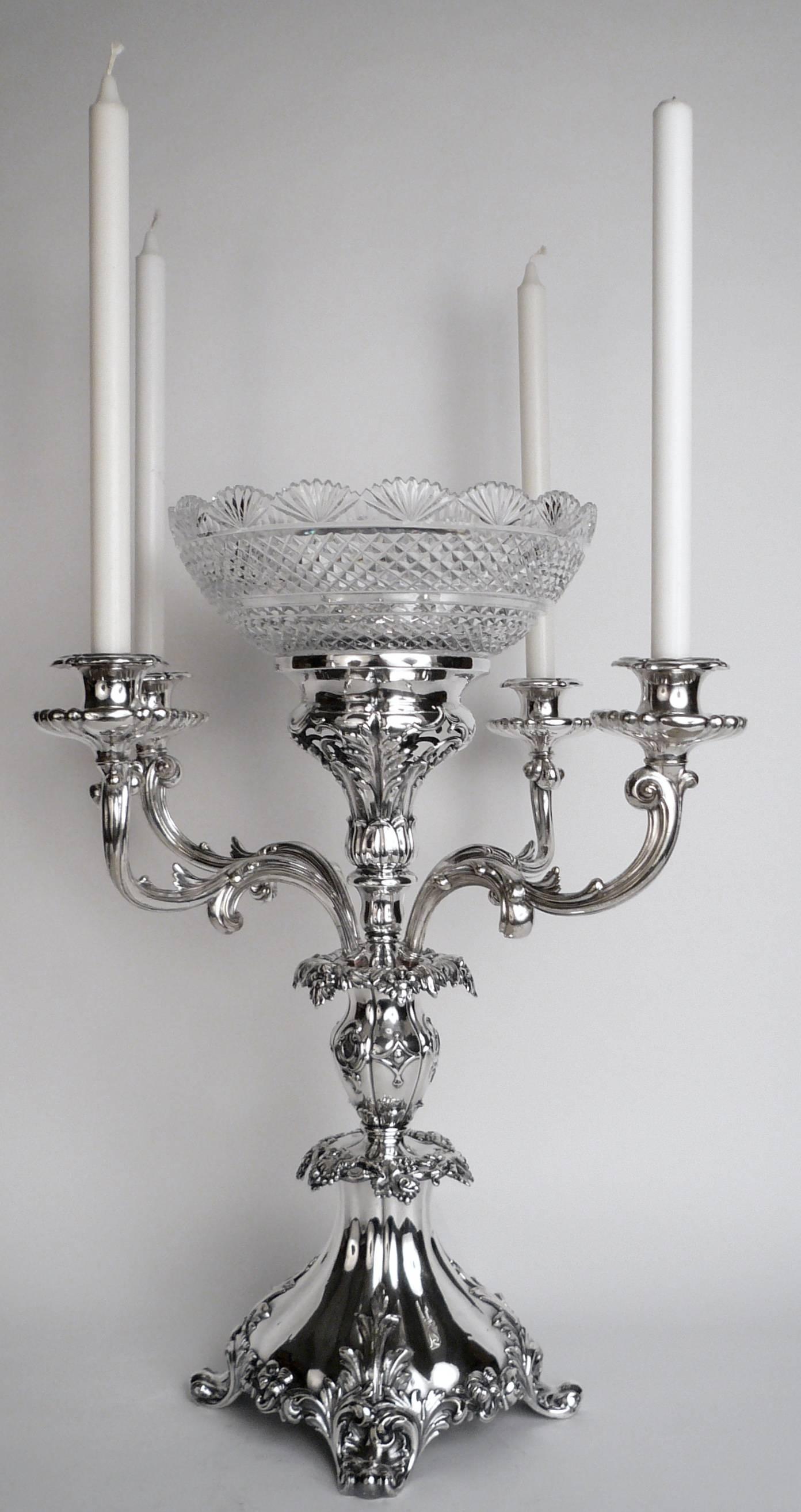 This impressive centerpiece features foliate, and vintage motifs, acanthus leaves, and scroll form feet.
The center bowl is beautifully cut and in excellent condition. Filled with fruit or flowers, this imposing epergne makes a grand statement.