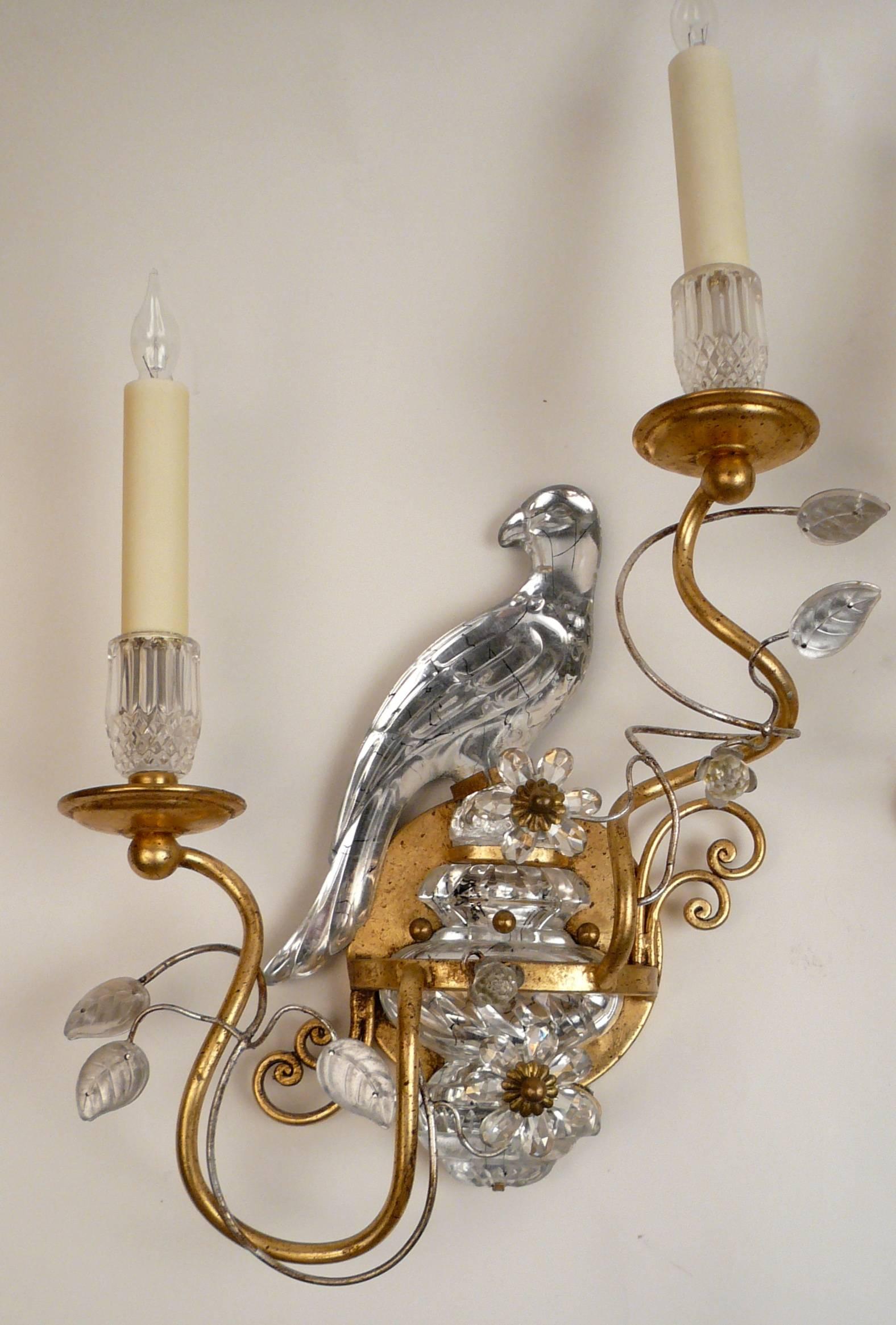 Modeled as birds perched atop crystal urns, these four wall lights are a fine example of the iconic sconces, originally designed by Maison Bagues, Paris. The mirror image two-light sconces have scrolling branches, and feature cut crystal leaves and