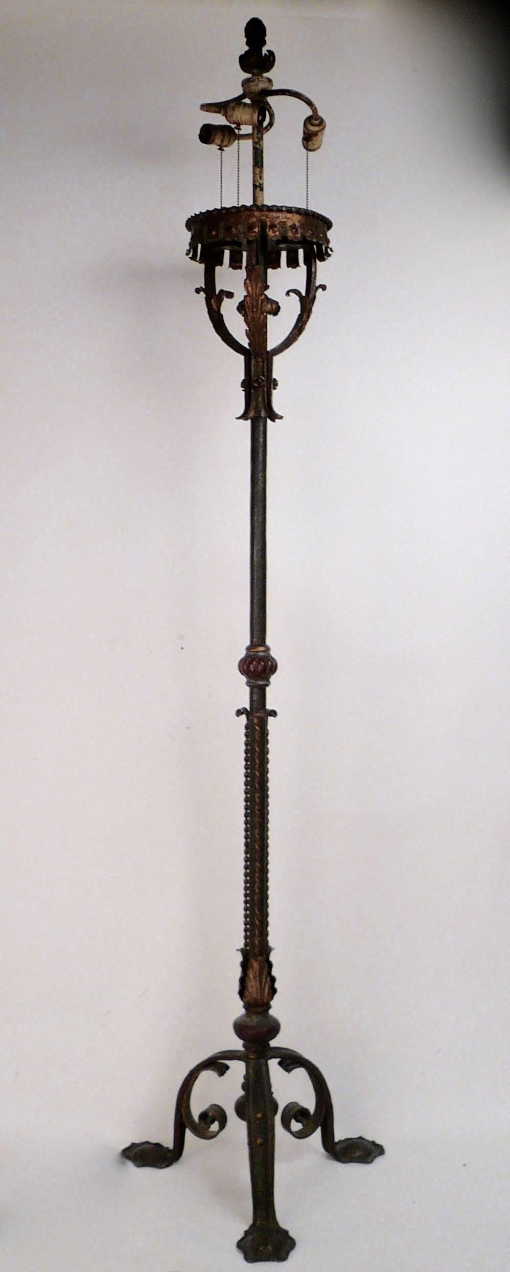 This impressive polychromed wrought iron torchere is handmade of heavy gauge metal. It features its original three light cluster and finial.