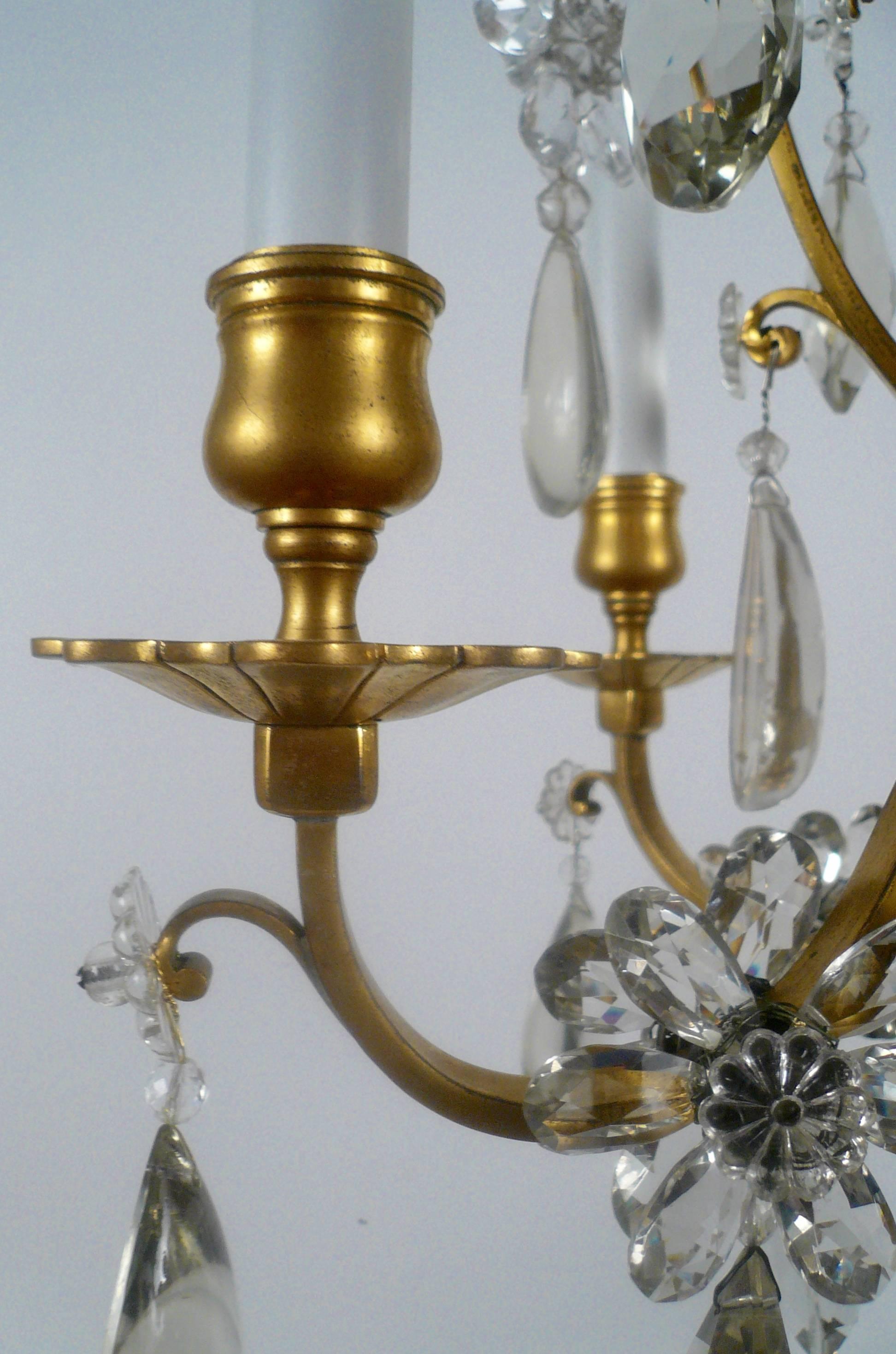Ce luminaire français de très belle qualité présente une section centrale en forme de harpe suspendue à des pendentifs floraux en cristal taillé.