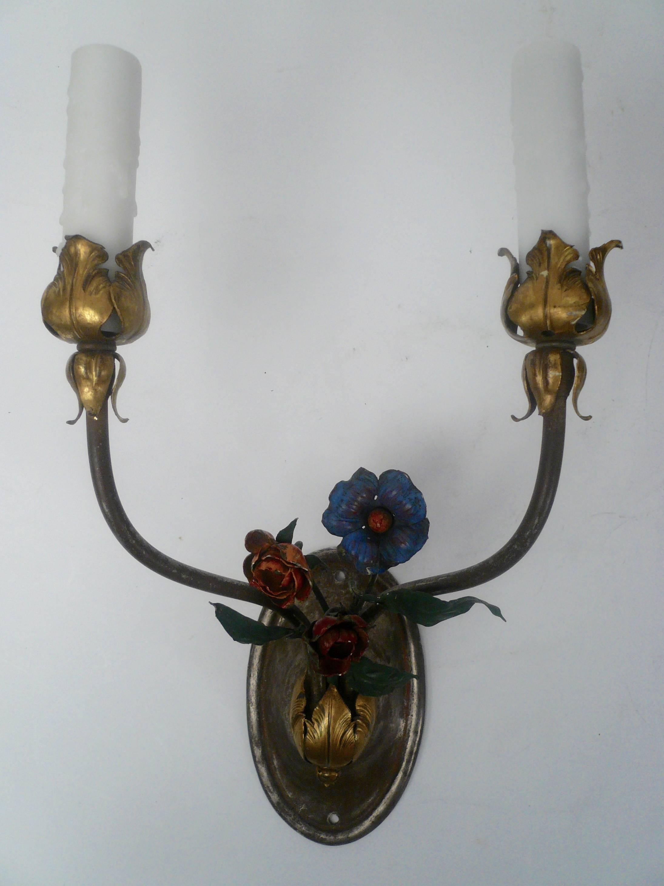 This pair of gilt and silvered bronze two light sconces have painted tole leaves and flowers.