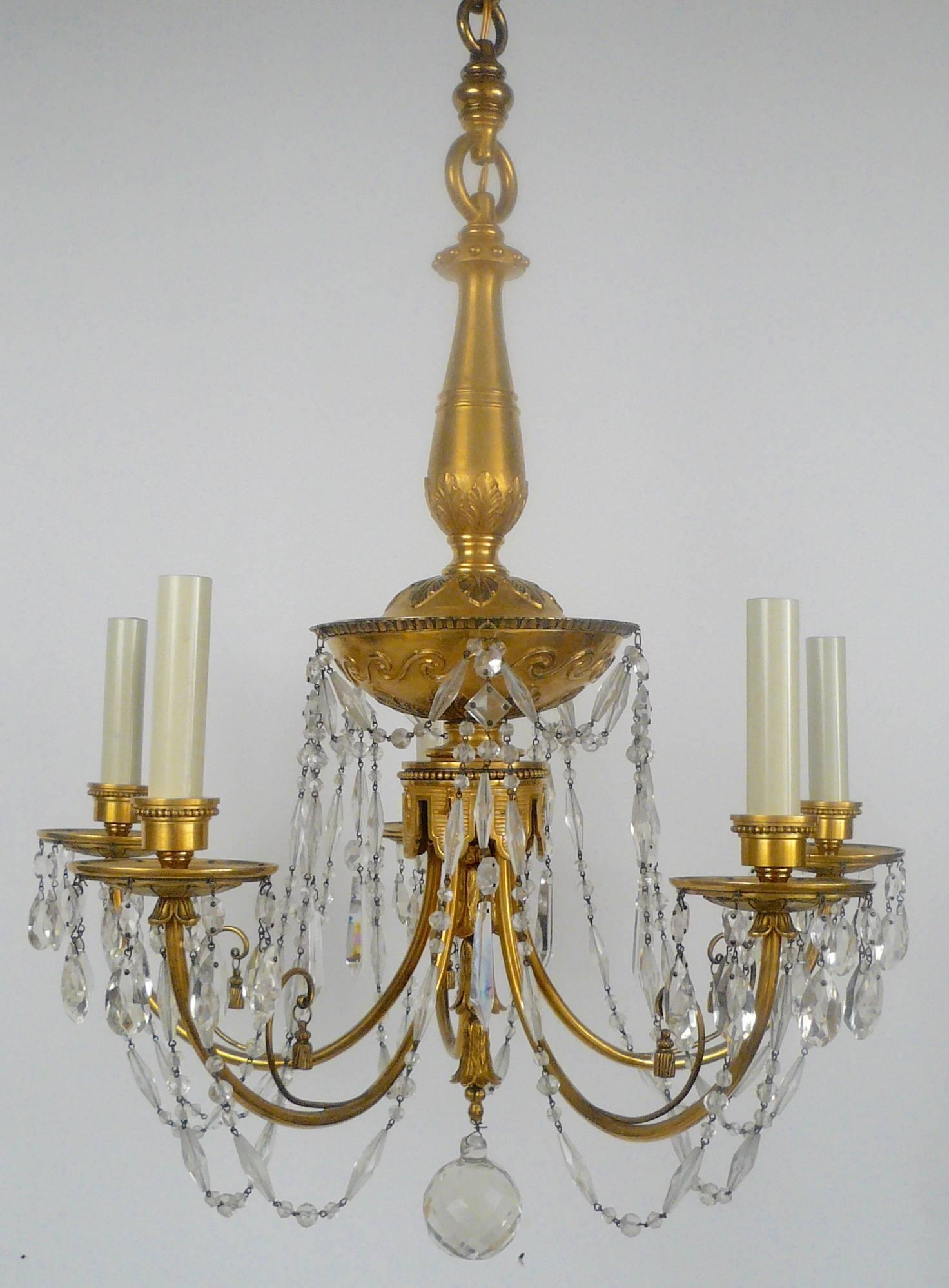 This five-light fixture by Caldwell has English neoclassical motifs, and retains it's original gilt bronze finish.