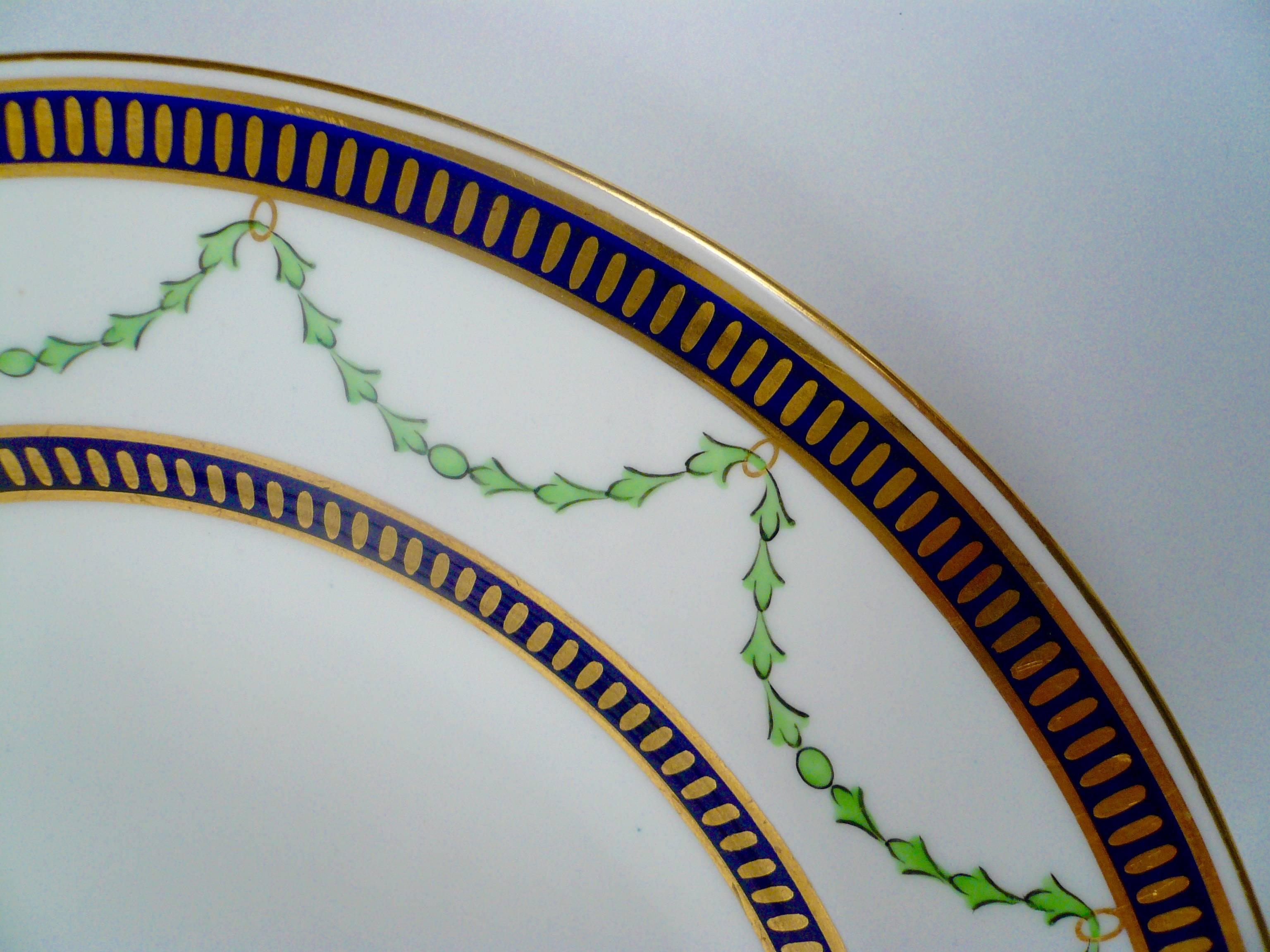 These cobalt and gilt derby porcelain plates feature green bellflower swags.
They were retailed at Phillips's of Mount Street, London.