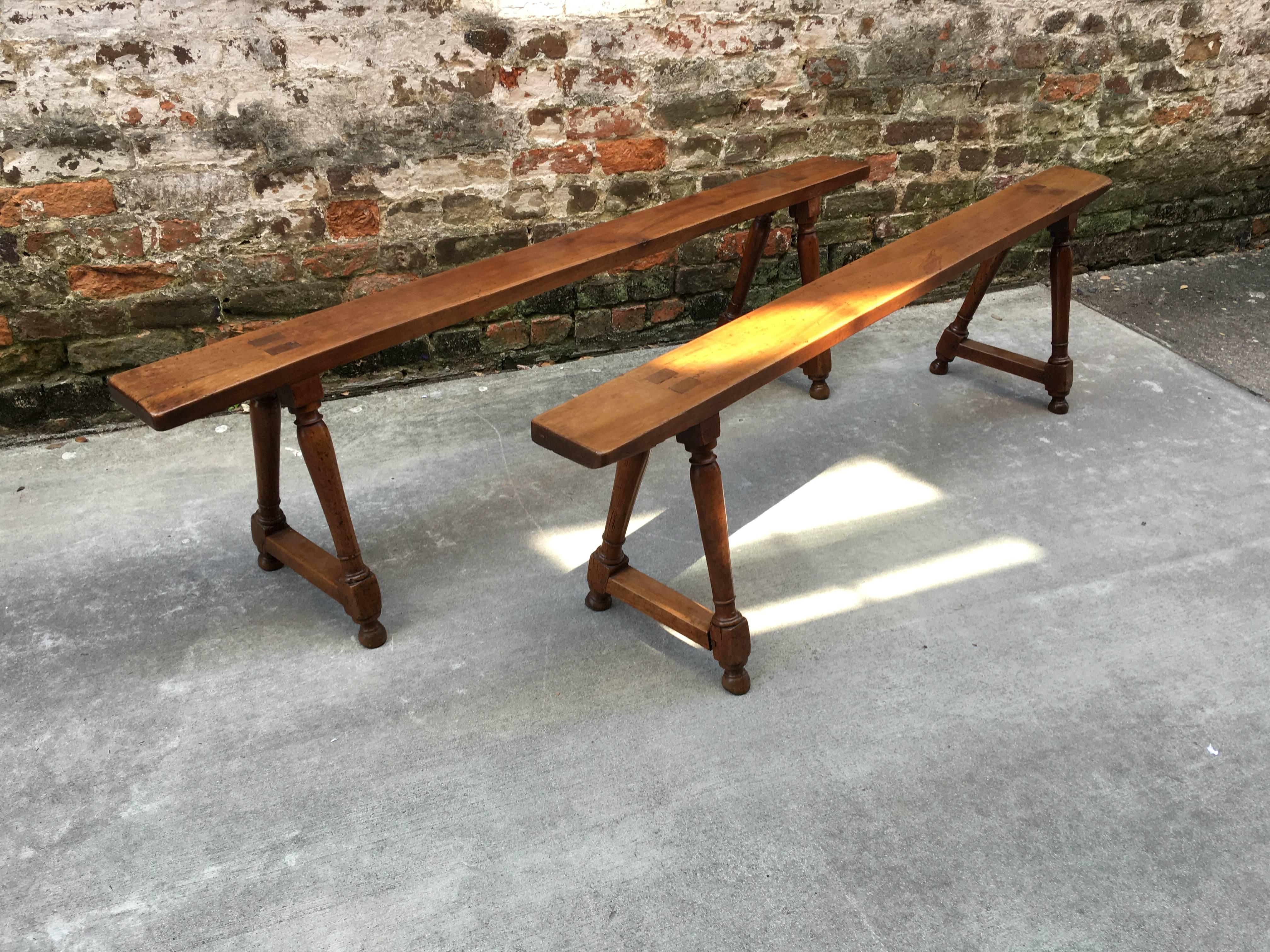 Pair of French walnut benches with turned leg stretcher bases. Very warm color and very stable for small sitting surface.