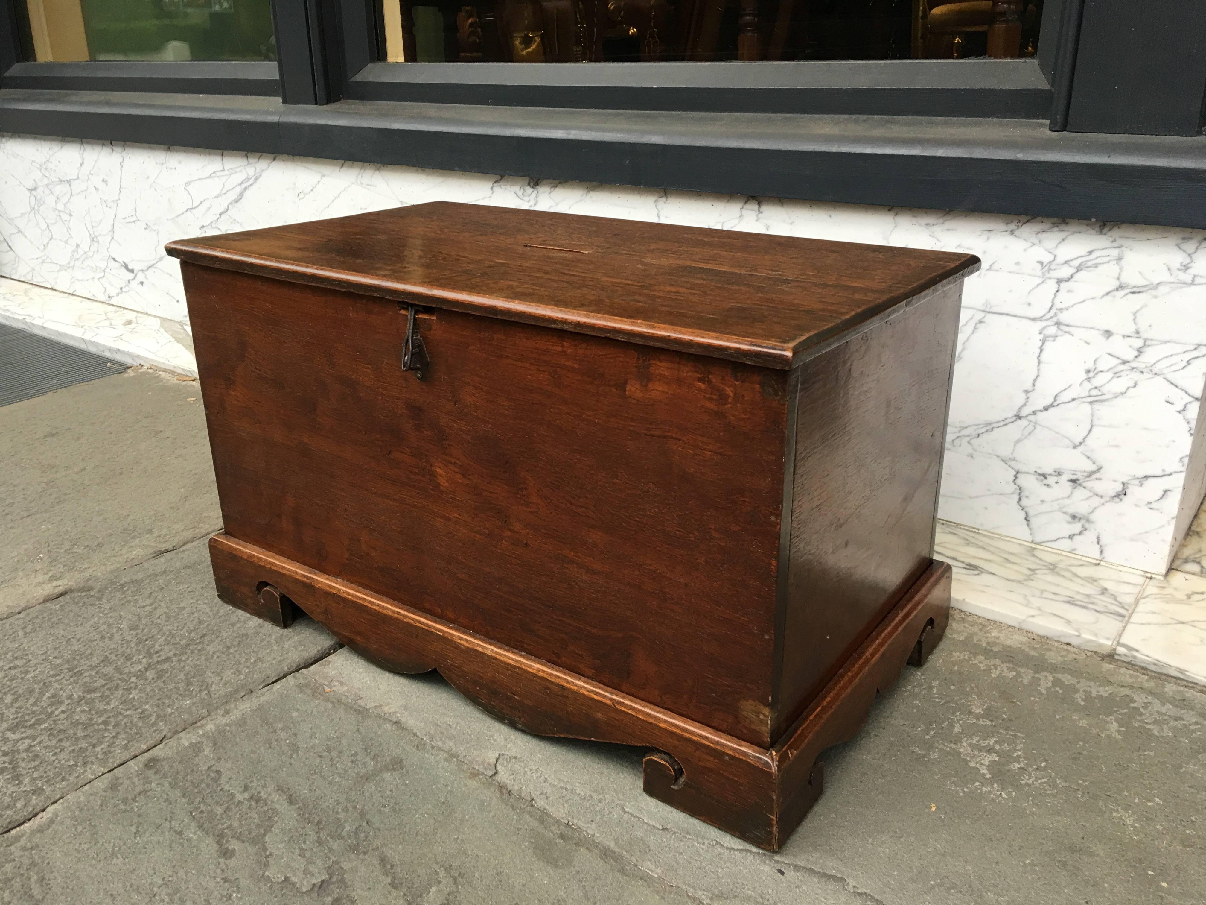 Small late 19th century box with top slot to deposit money. Nicely carved bracket foot base.