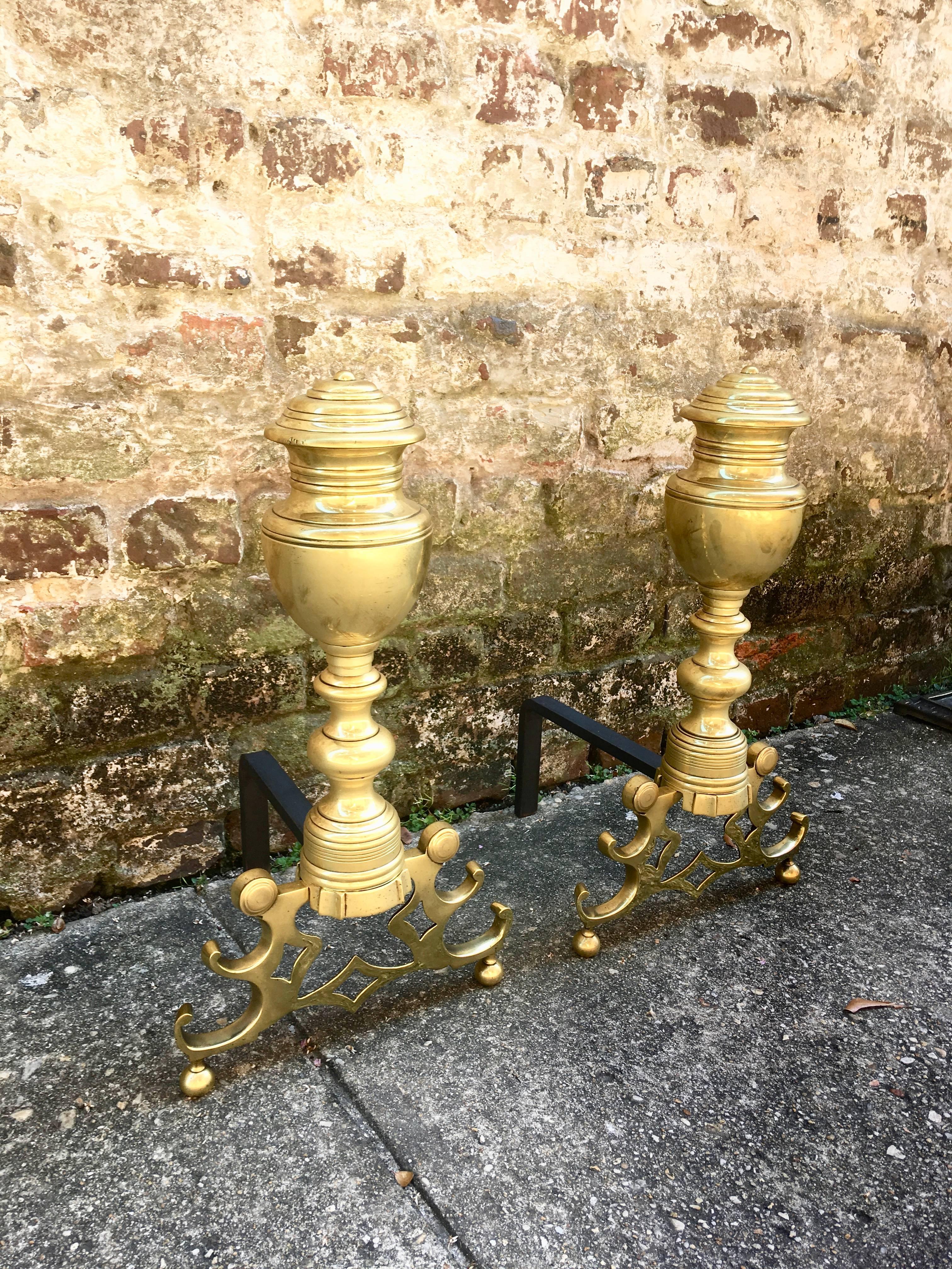 American urn top andirons with ornate base.