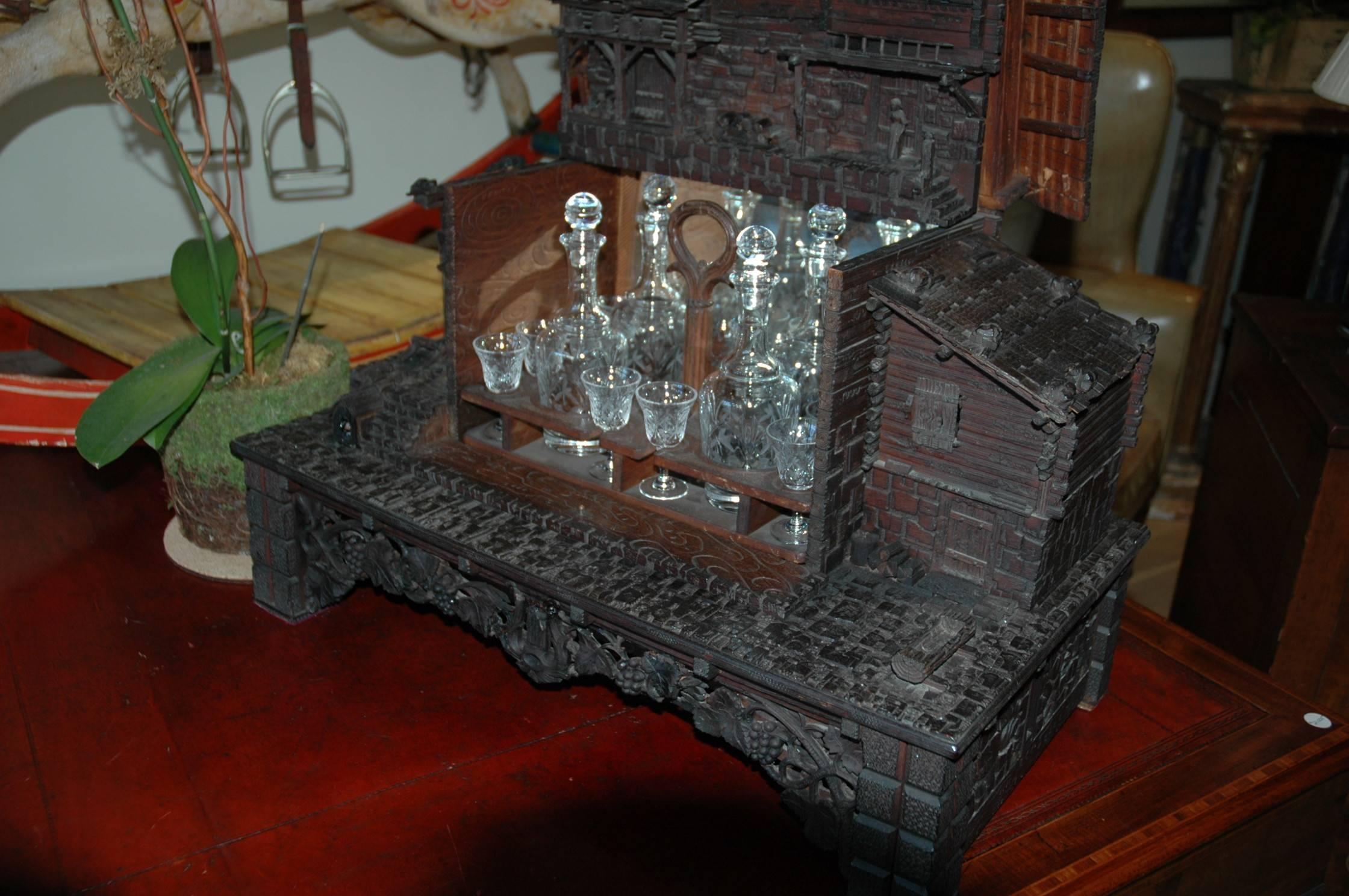 A very finely carved Swiss Chalet with complete bar set as a fitted interior. Removing the bar set activates the music box positioned in lower body of the house. These were made for the export market in the early 1900s.