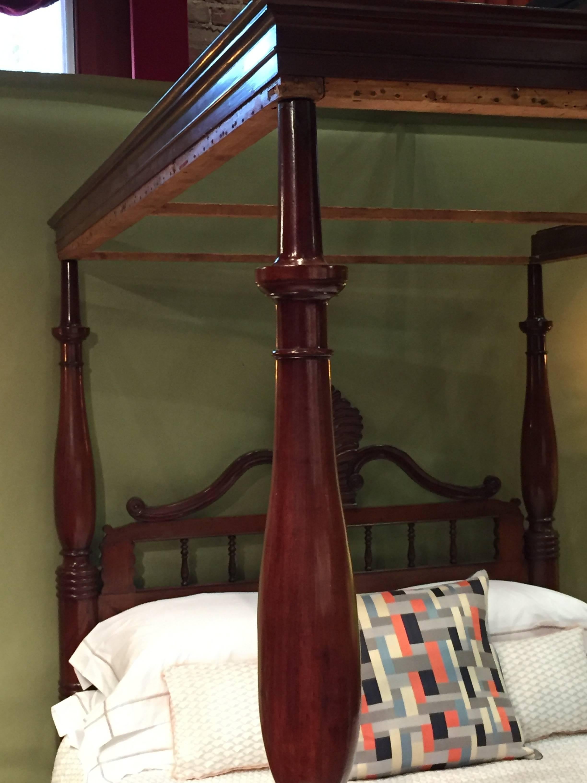 19th century West Indian mahogany four post bed. Pineapple accent as pediment of headboard with nicely turned posts and original foot rail.