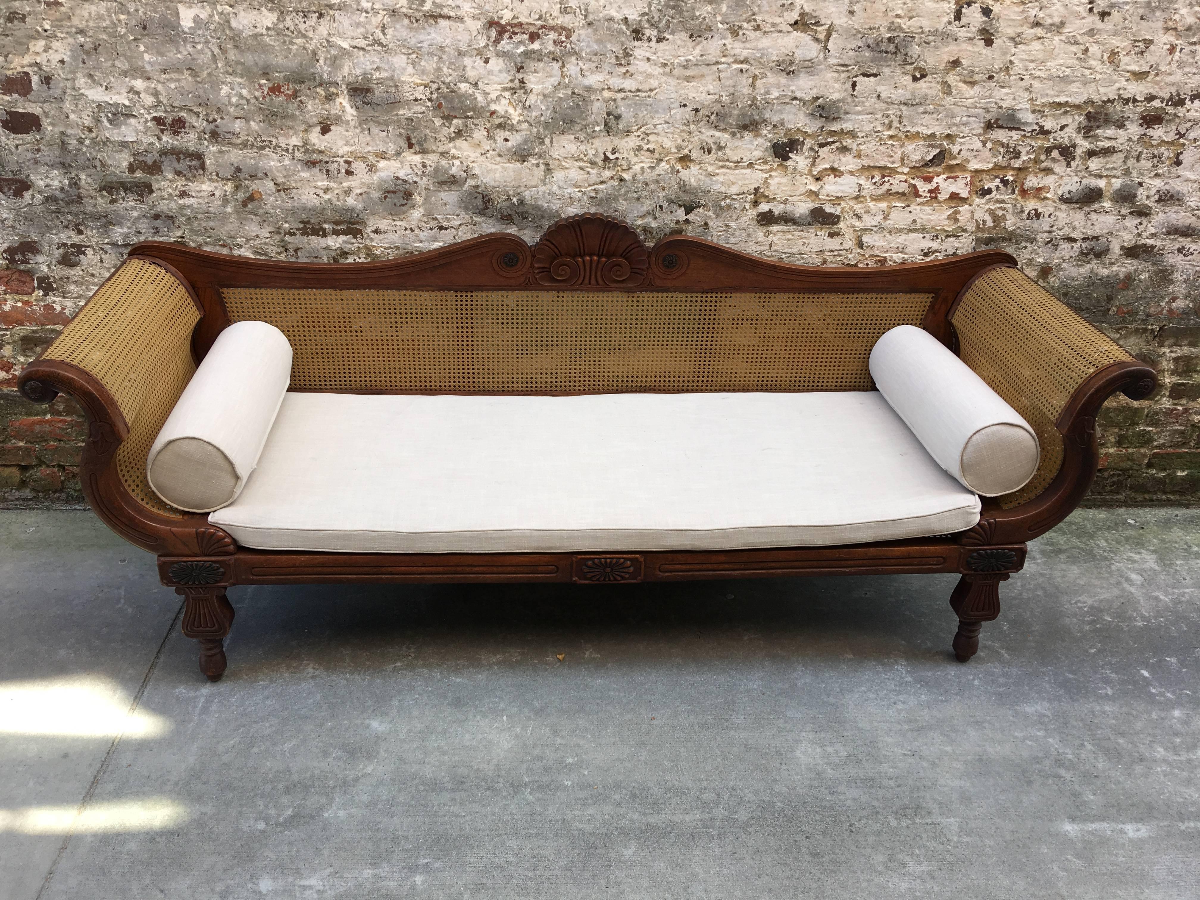 West Indian rolled arm sofa with carved back and leg, circa 1840 with restored cane.