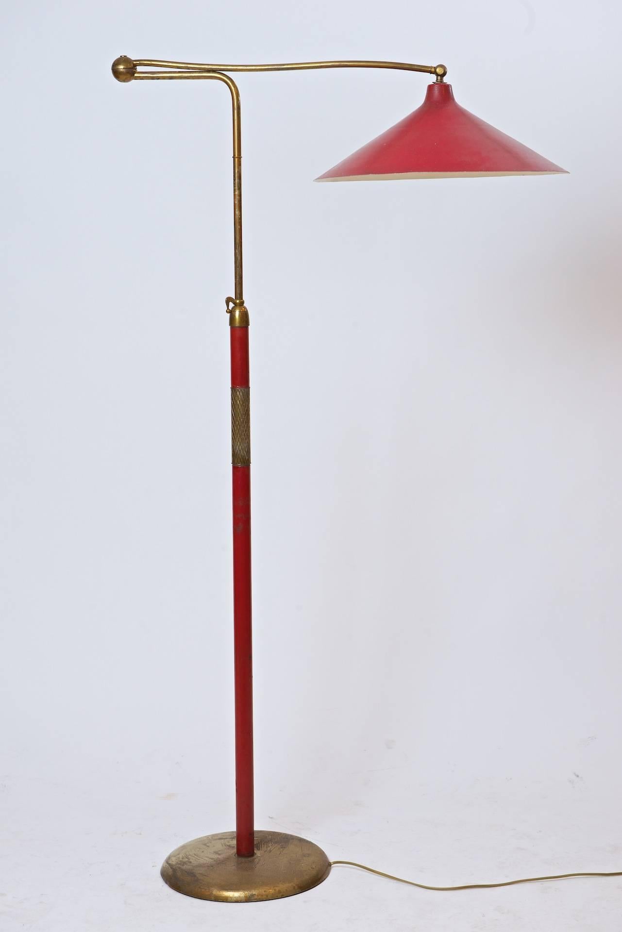 Brass, red stitched leather red laquer shade.

Height can be adjusted. Shade has possibly been replaced.
