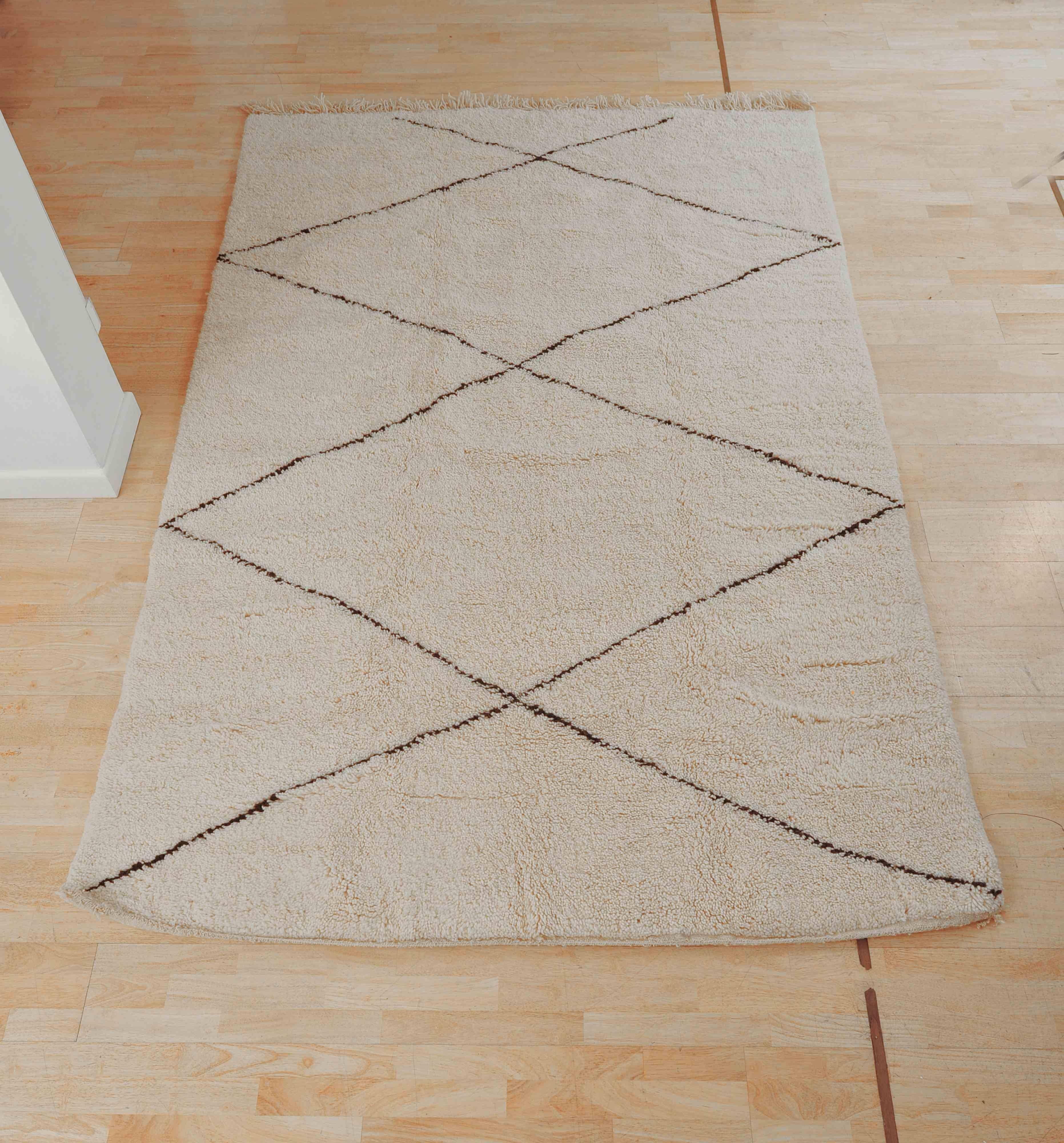 Simple contemporary Moroccan, Berber rug. 
An ivory white/cream color with black detail.

Hand-knotted.
100% wool
(weighs 12 kilos)