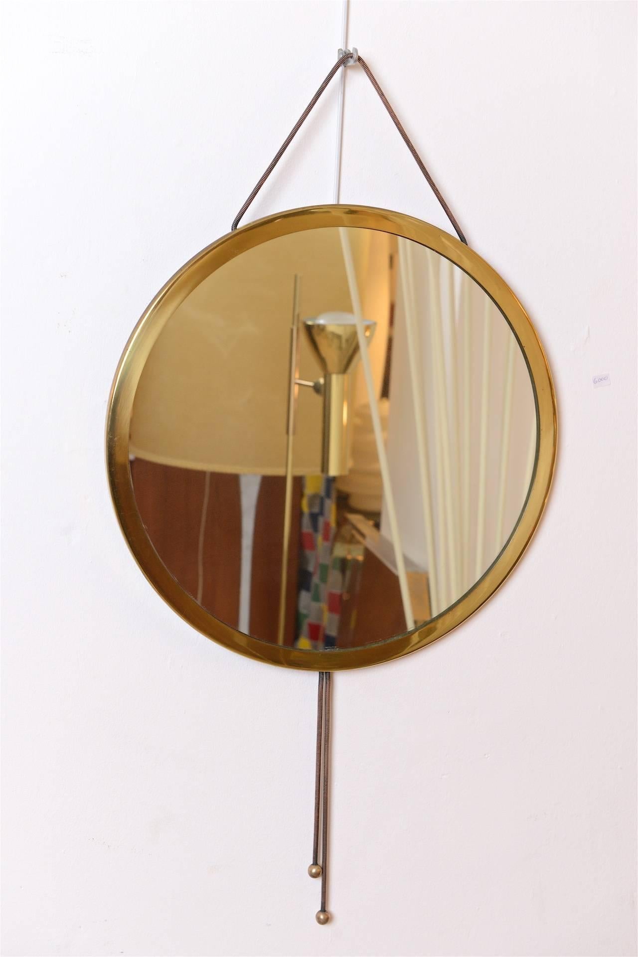 Very chic circular mirror with brass frame. 
Tassels in copper and brass.

(Details on mirror can be polished to copper and brass, 
tassels have been left in original condition).