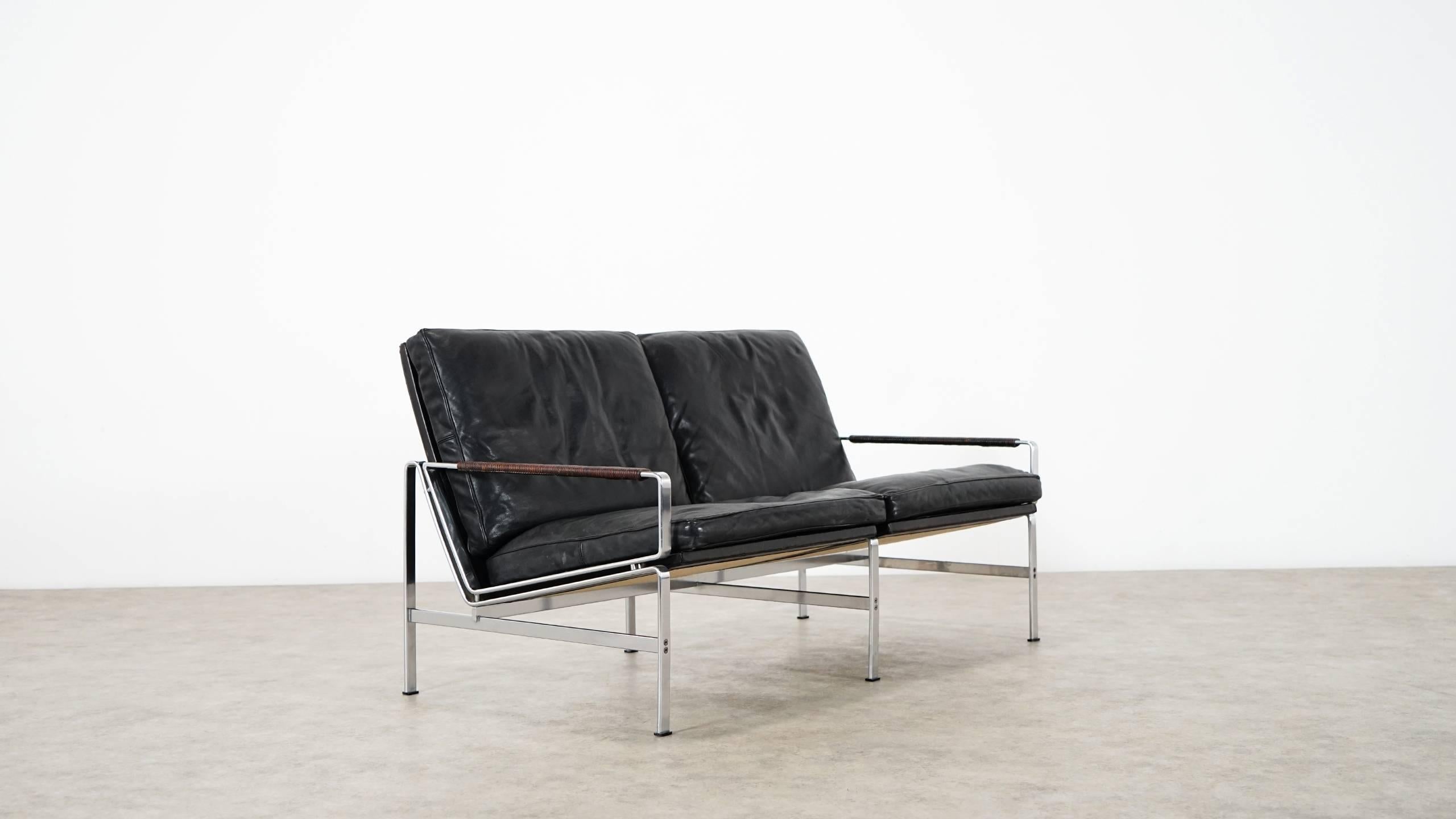 Two-seat sofa FK 6720 by Preben Fabricius & Jørgen Kastholm, designed in 1967.
Made by Kill International, Germany.

Black leather with natural patina, chromed steel frame, the armrests are wrapped with thin leather strap - a wonderful detail!