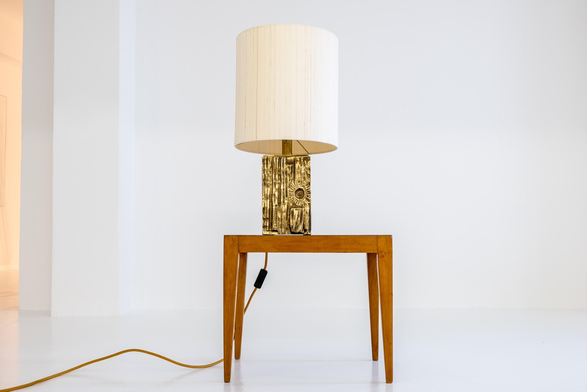 Desk lamp attributed to Luciano Frigerio by Frigerio Di Desio, Italy, circa 1970s.

Impressive and very recognizable table lamp with a sculptural, massive brass foot with cast brass plates front and back, showing a sunset behind trees in an