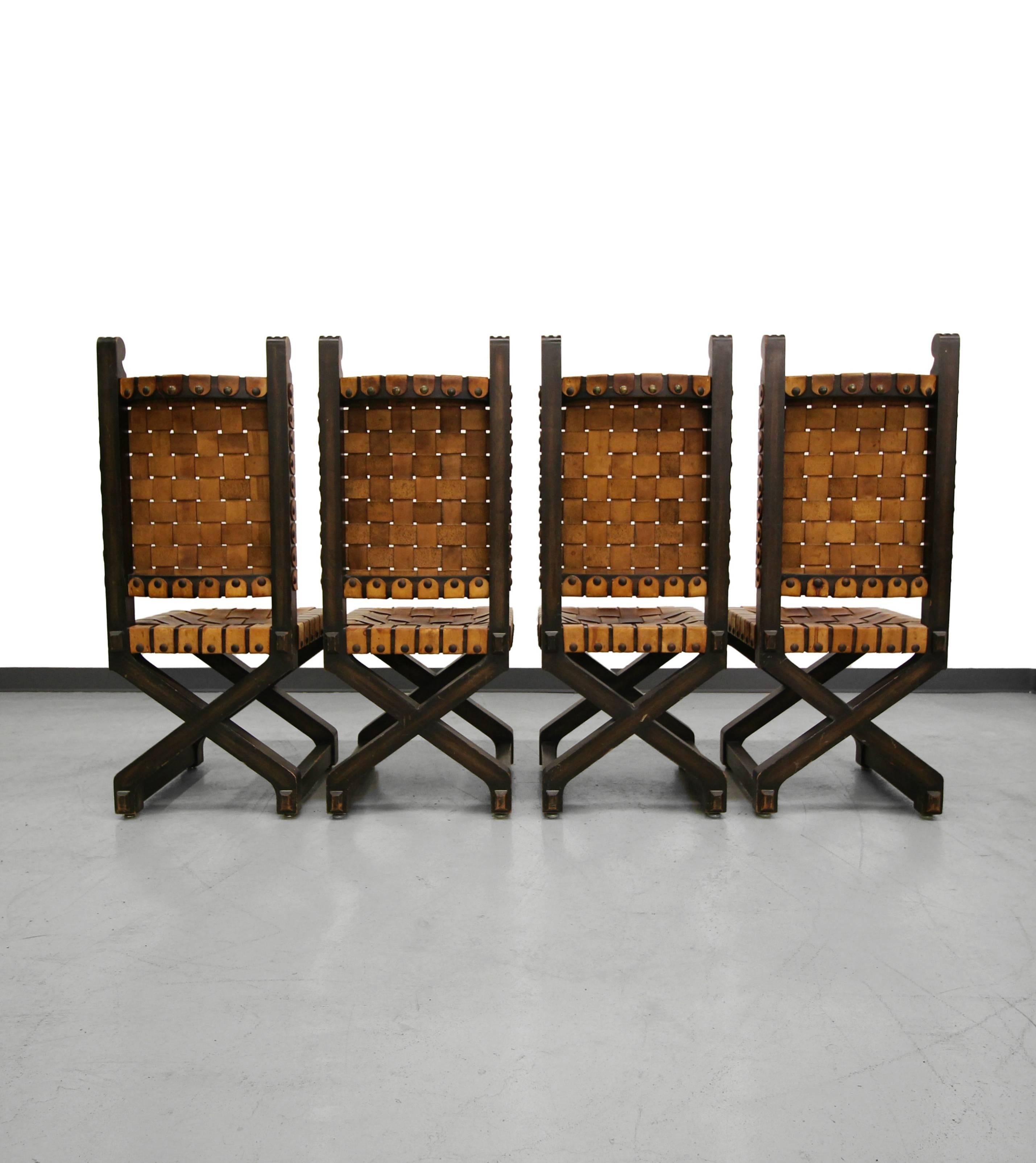 Set of four, perfectly patinated, woven leather, wood frame dining chairs, with large brass nailhead details. They were made in Mexico and are of superior craftsmanship. Chairs have beautifully worn leather for that great Industrial look.