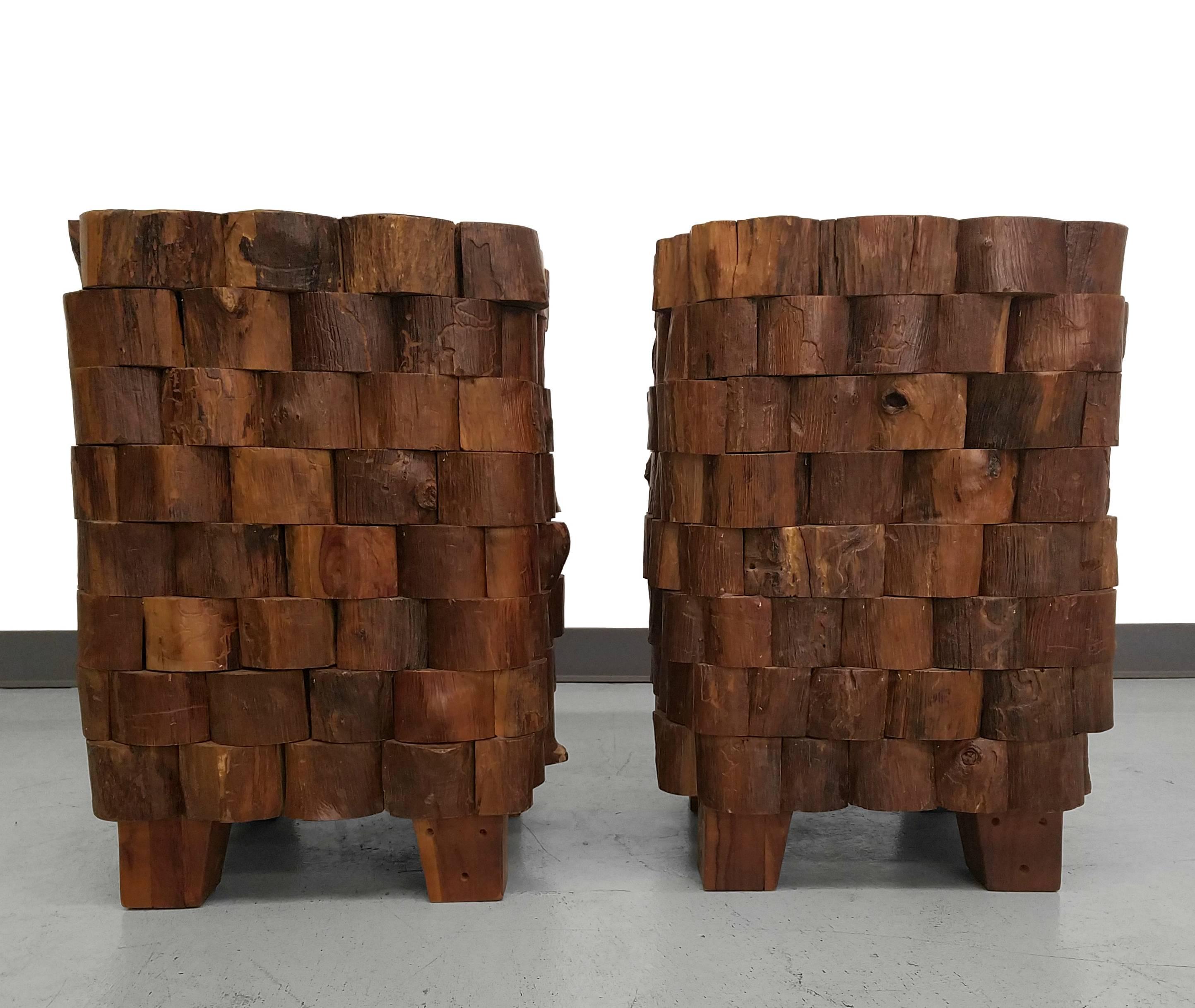 Extremely unique and possibly one of a kind pair of stacked wood side tables. These tables are comprised of many wood end cuts all stacked to make a very unique, extremely textured design element. These are that eclectic conversation piece that