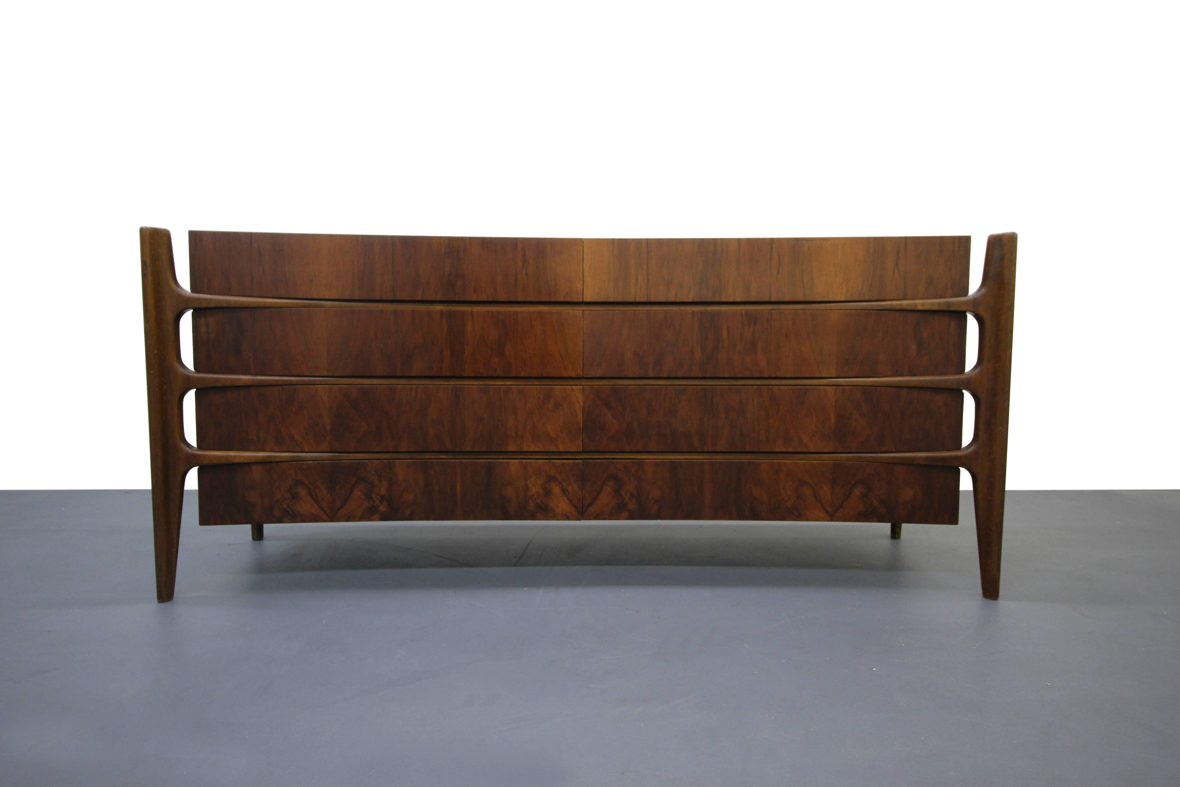 Highly sought after eight-drawer dresser with curved structure, booked matched woodwork on the drawer fronts and solid wood, edge mounted legs. This dresser is hands down, the most well-made piece of casework we've ever had the pleasure of sourcing.