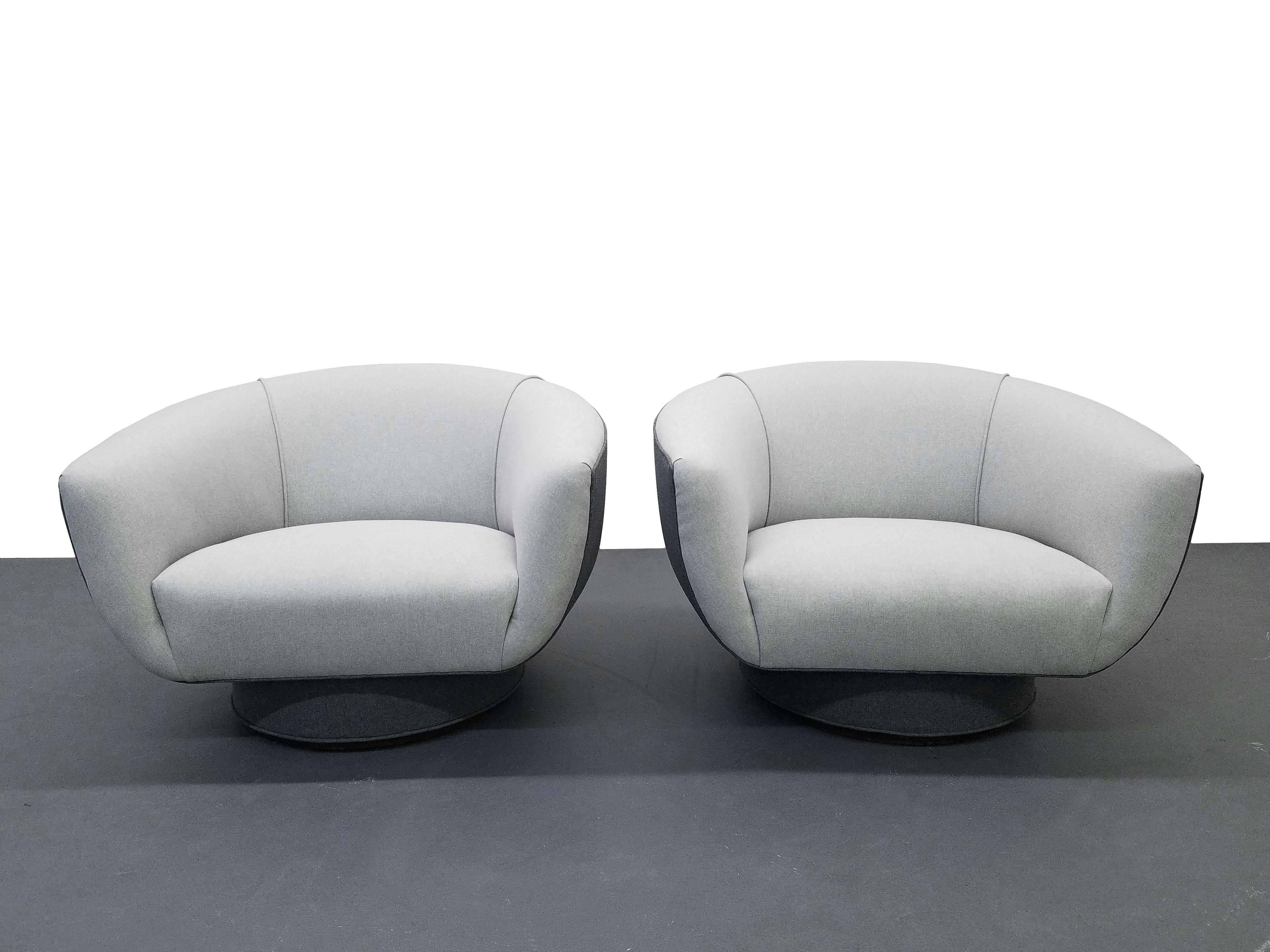 Beautiful oversized pair of Mid-Century swivel lounge chairs by Harvey Probber. Chairs have beautiful shape and style. 

The chairs have been modernized from they're original tufted white vinyl to a soft tone on tone grey cotton based felt fabric.