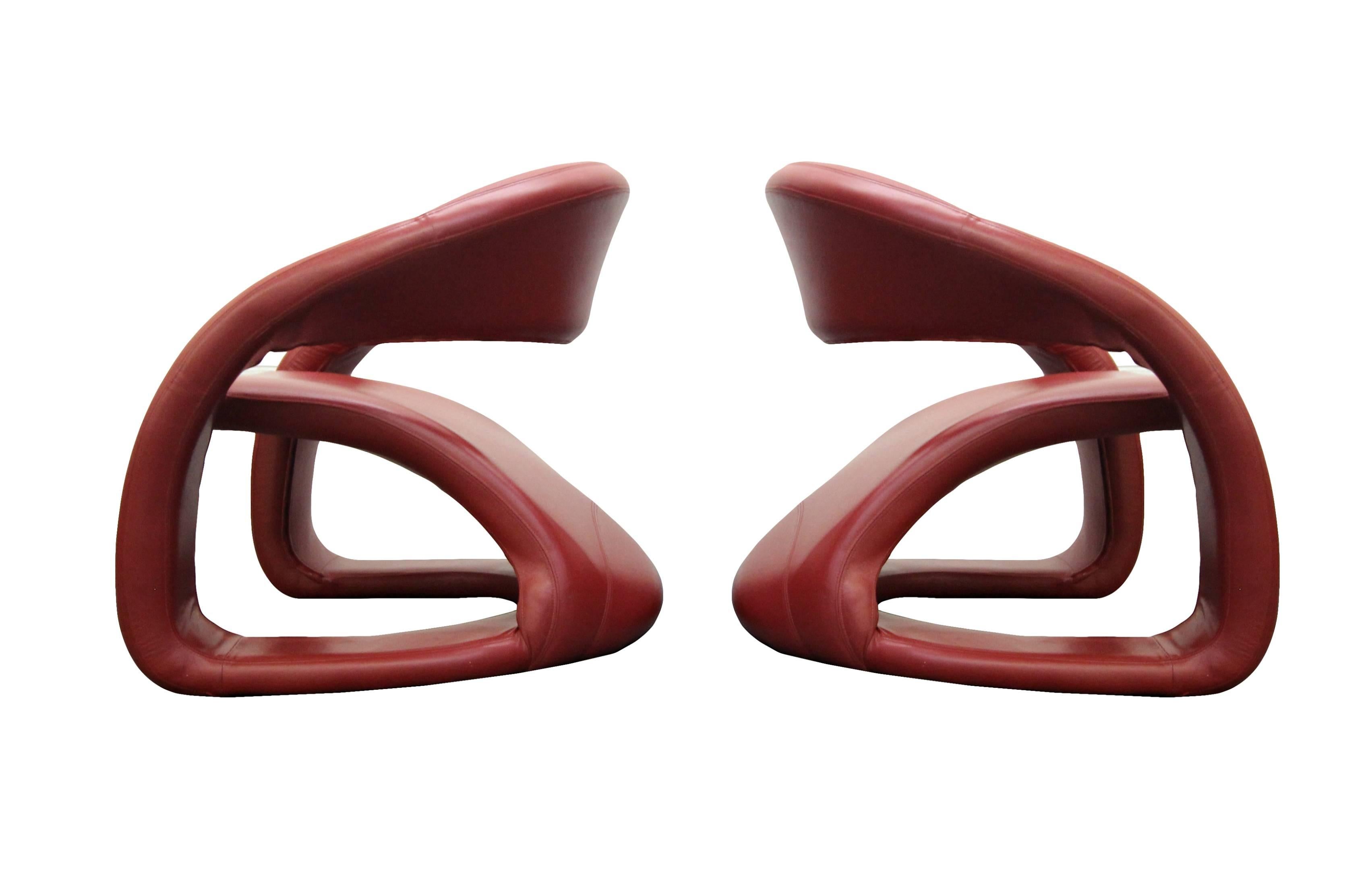 Pair of Memphis Milano style cantilevered lounge chairs. High quality chairs finished in bright red leather. These sculptural chairs are more like art pieces than furniture. These chairs are extremely comfortable making them dual purpose, form and