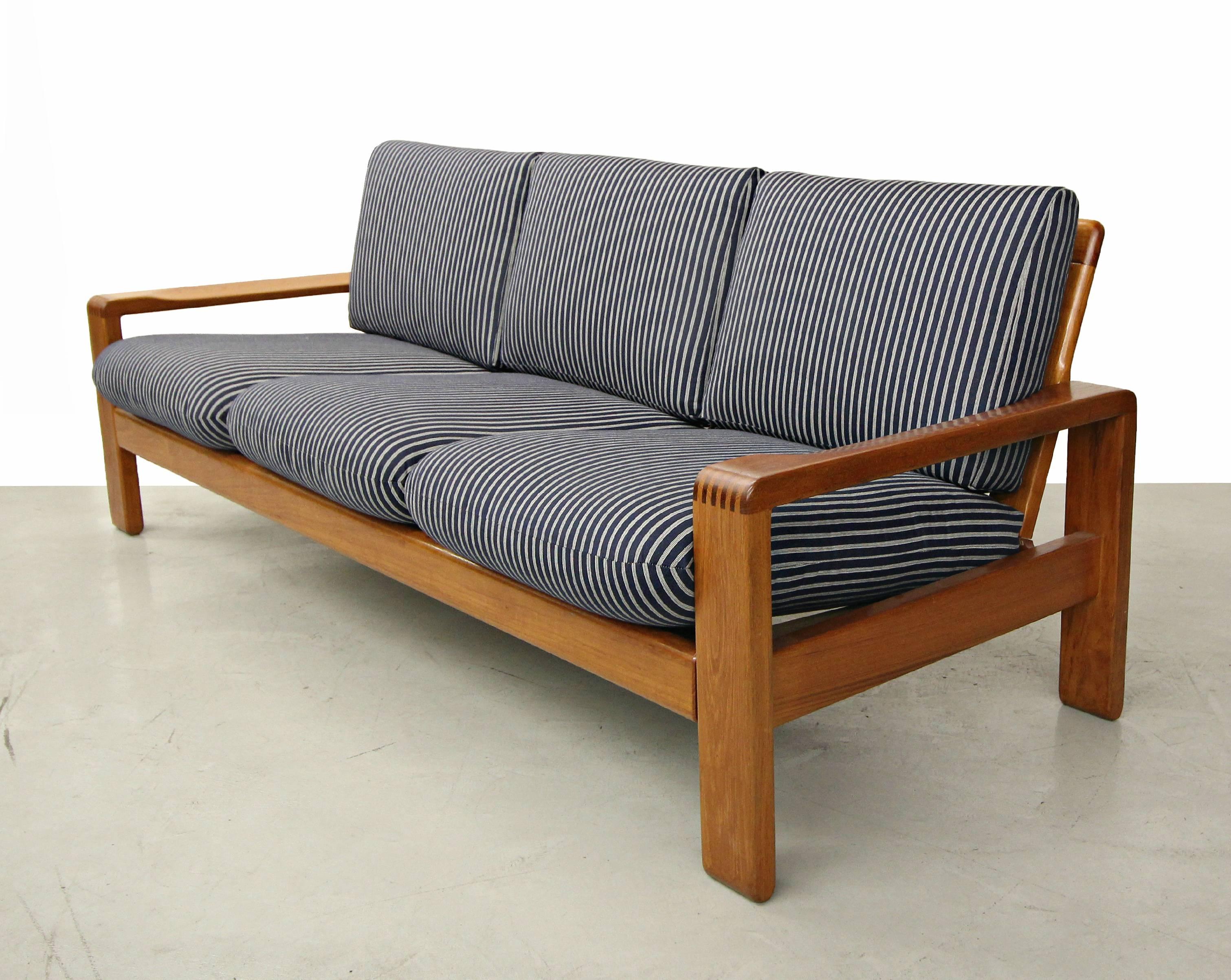 This is the classically perfect, solid teak, Danish sofa designed by HW Klein for Bramin Mobler. This is a beautifully designed sofa with gorgeous dovetail joint details and an open slatted back. This sofa is quite substantial and weighty in
