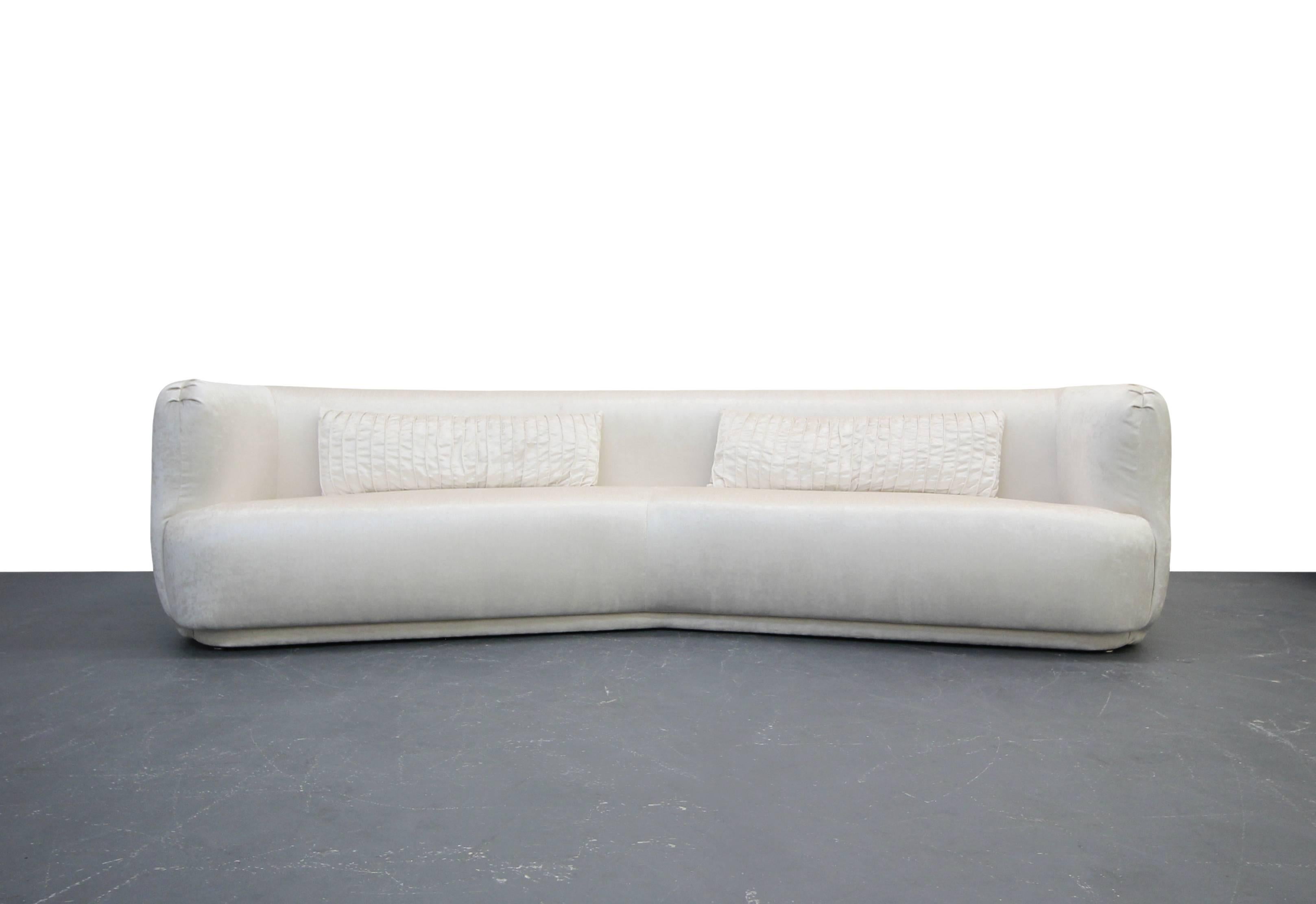 Freshly reupholstered in a beautiful cream color, high quality velvet, this beauty is dressed to impress. Angled sofas are rare, and to find one with these round edges is basically impossible. Stunning pieces, completely restored and ready for its