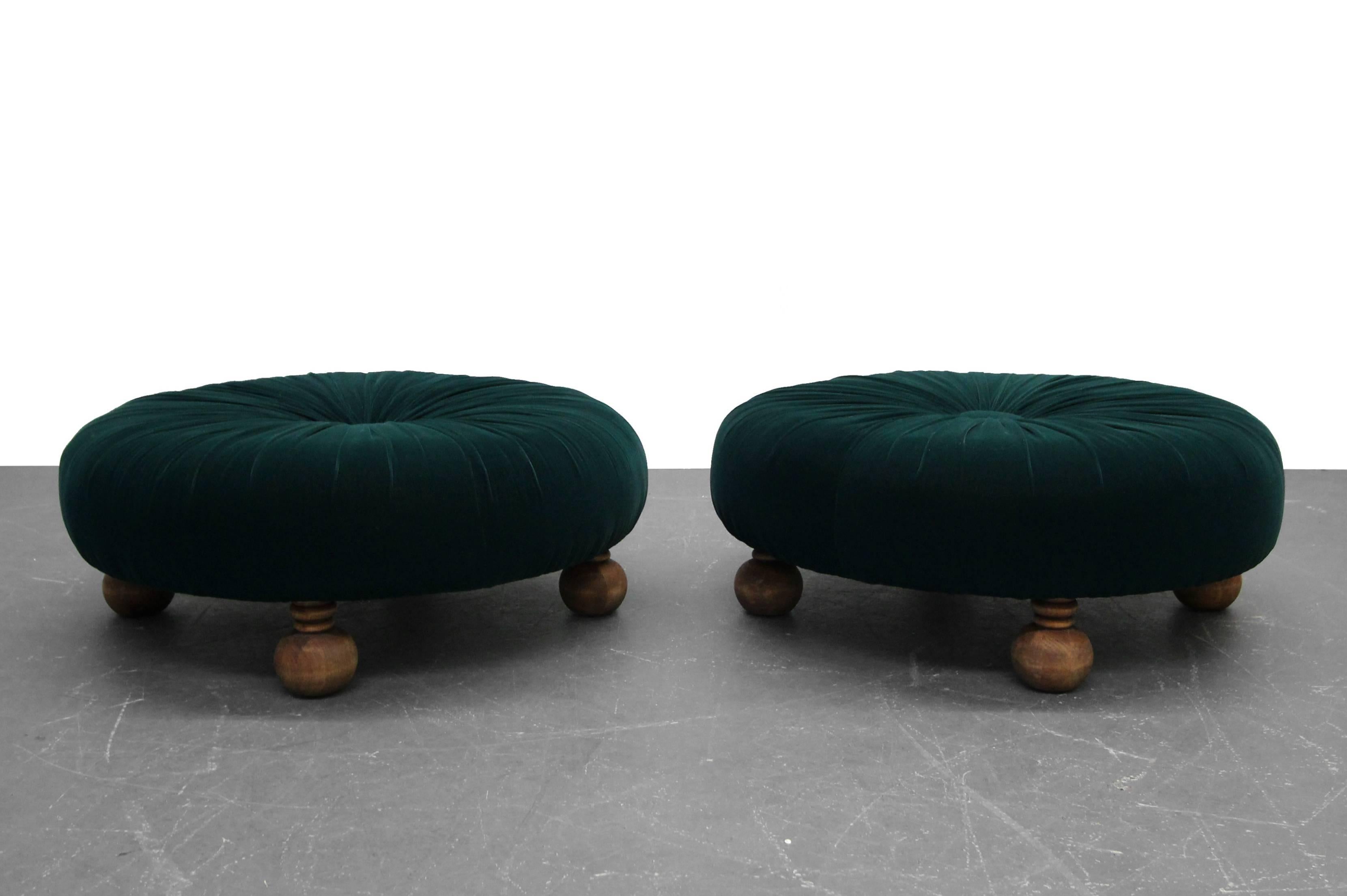 Rare and beautiful pair of antique large and low floor ottomans. The ottomans have hand-turned legs and have been reupholstered in a stunning emerald green velvet, complete with large centre button and hand pleating. These are gorgeous. Art