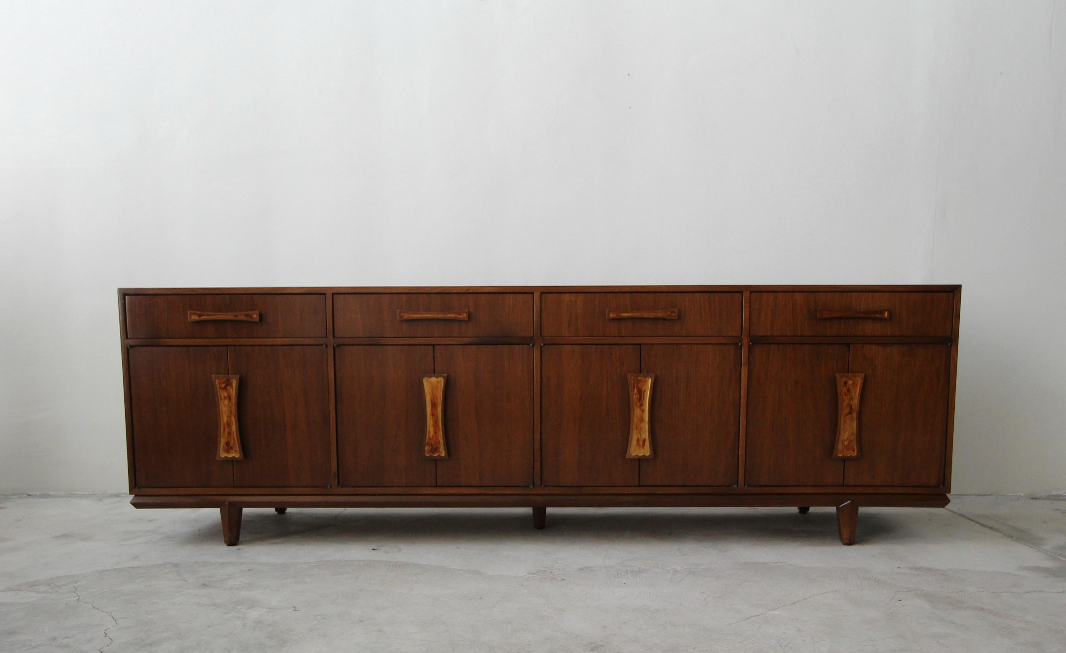 Exquisite midcentury walnut credenza by Cal Mode Furniture. If your looking for a large case piece with a simple and beautiful look, you've found it. The unique resin inlay handles and sculpted details, give this piece stunning character.

Cabinet