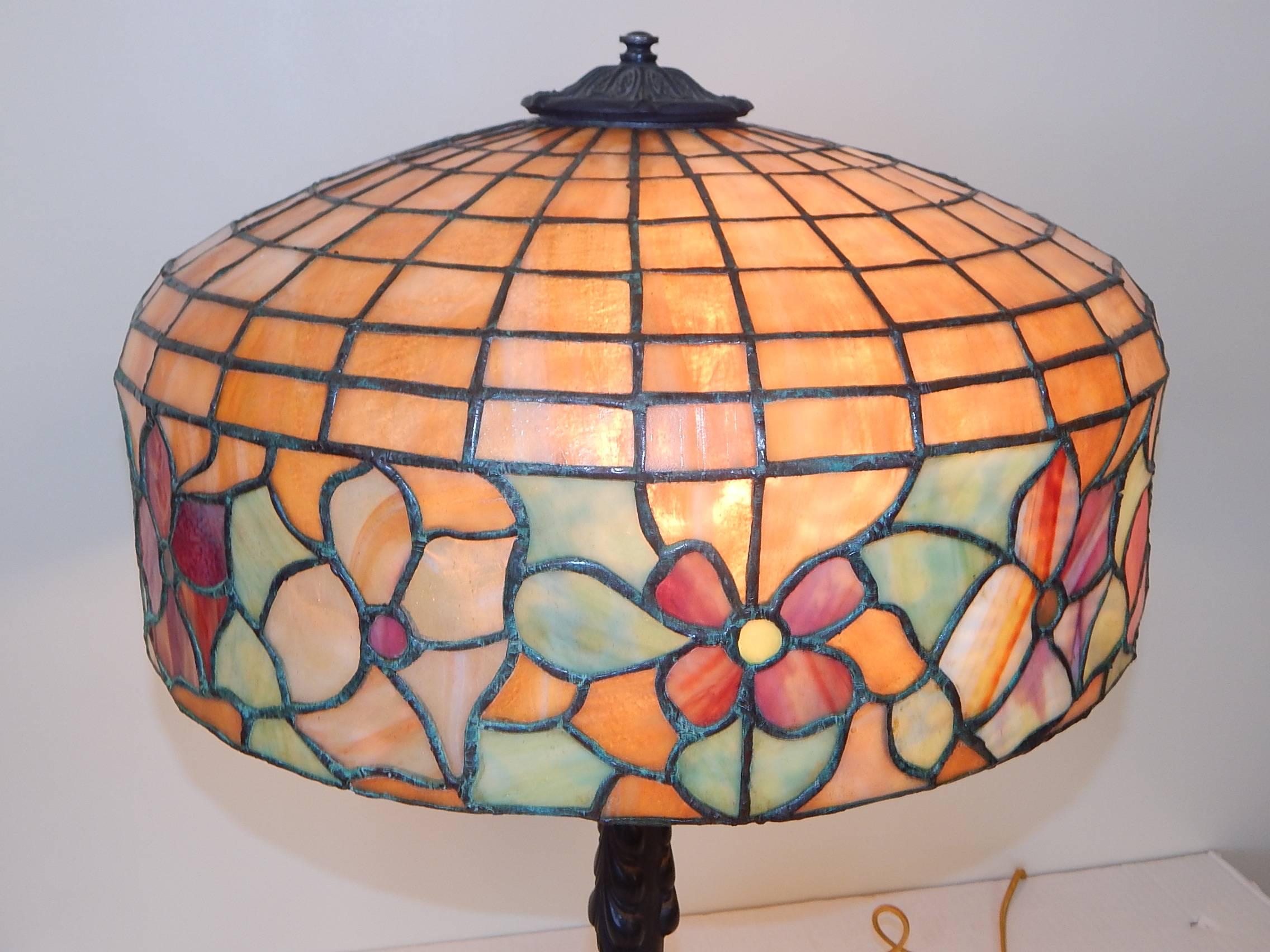 A lovely and good size antique leaded glass table lamp, with vivid colors.
The beautiful top shade mounted on a dark green patinated metal base.
Shade is signed Bradley & Hubbard. This was a well-known company that produced these types of