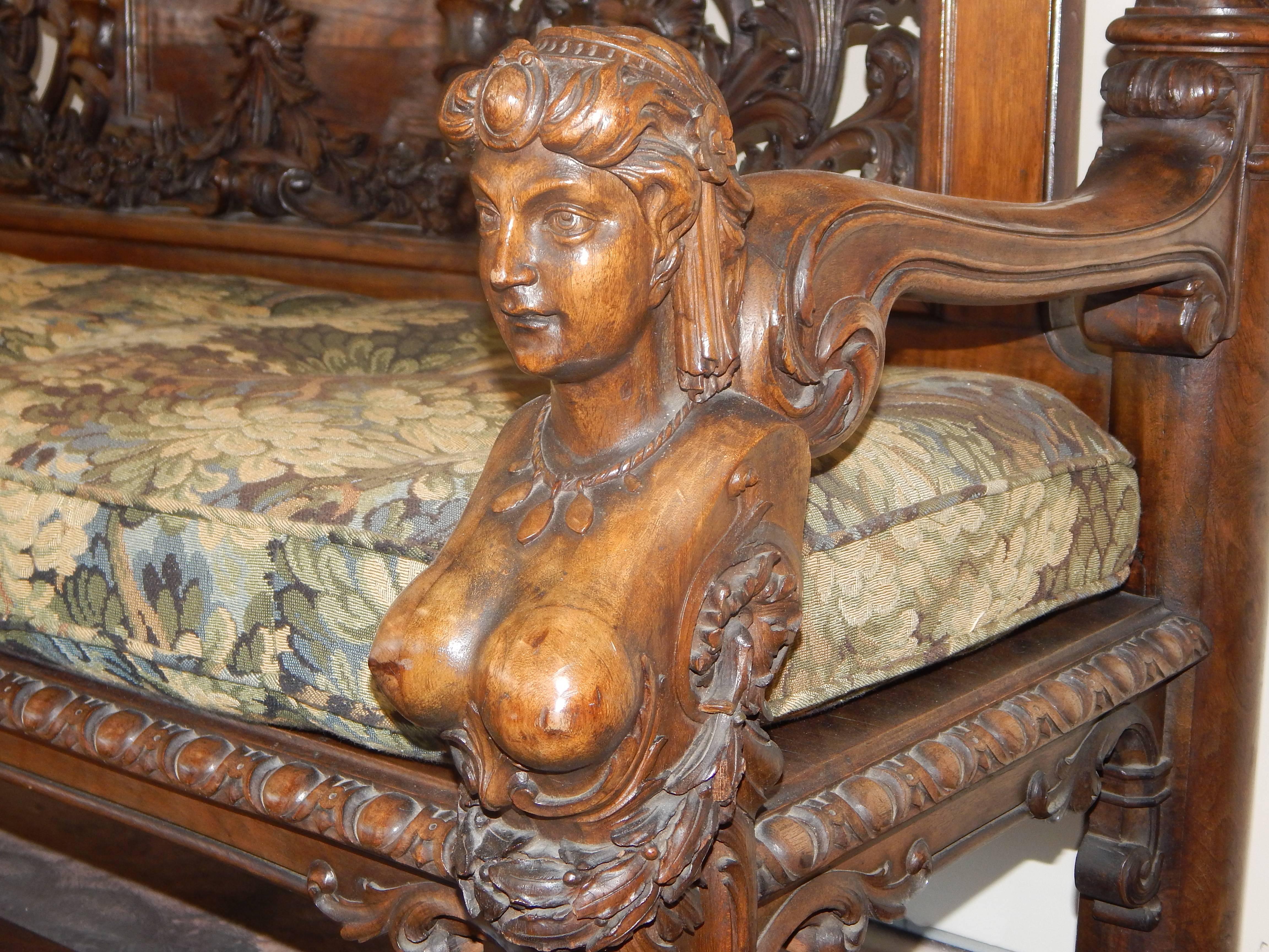 A magnificent large carved walnut settee, or hall bench, featuring ladies heads,
cupids and wreaths. Excellent carving and wonderful patina.