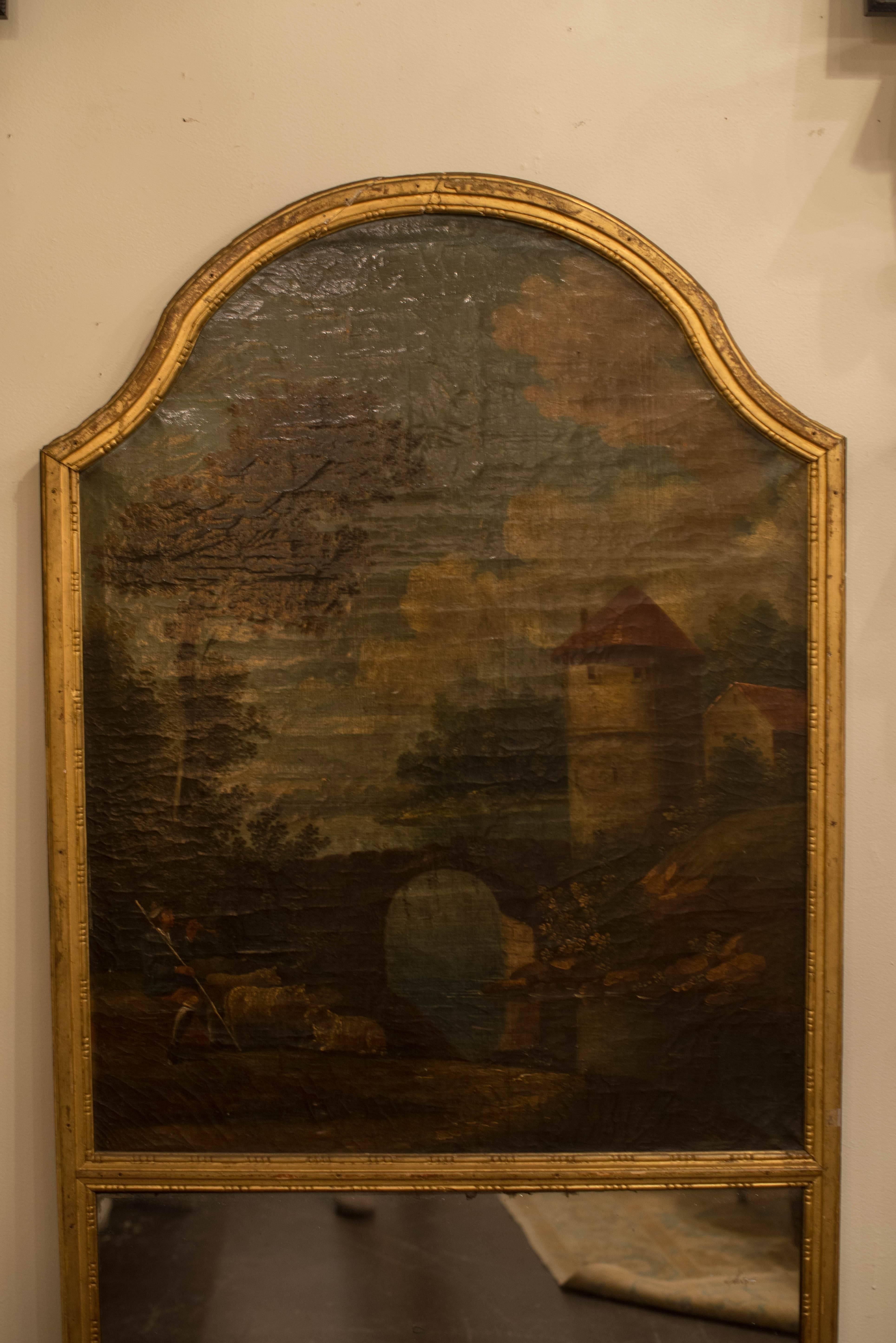 This incredible 18th century French giltwood trumeau mirror features a lovely curved top and beautiful oil on canvas painted country scene.