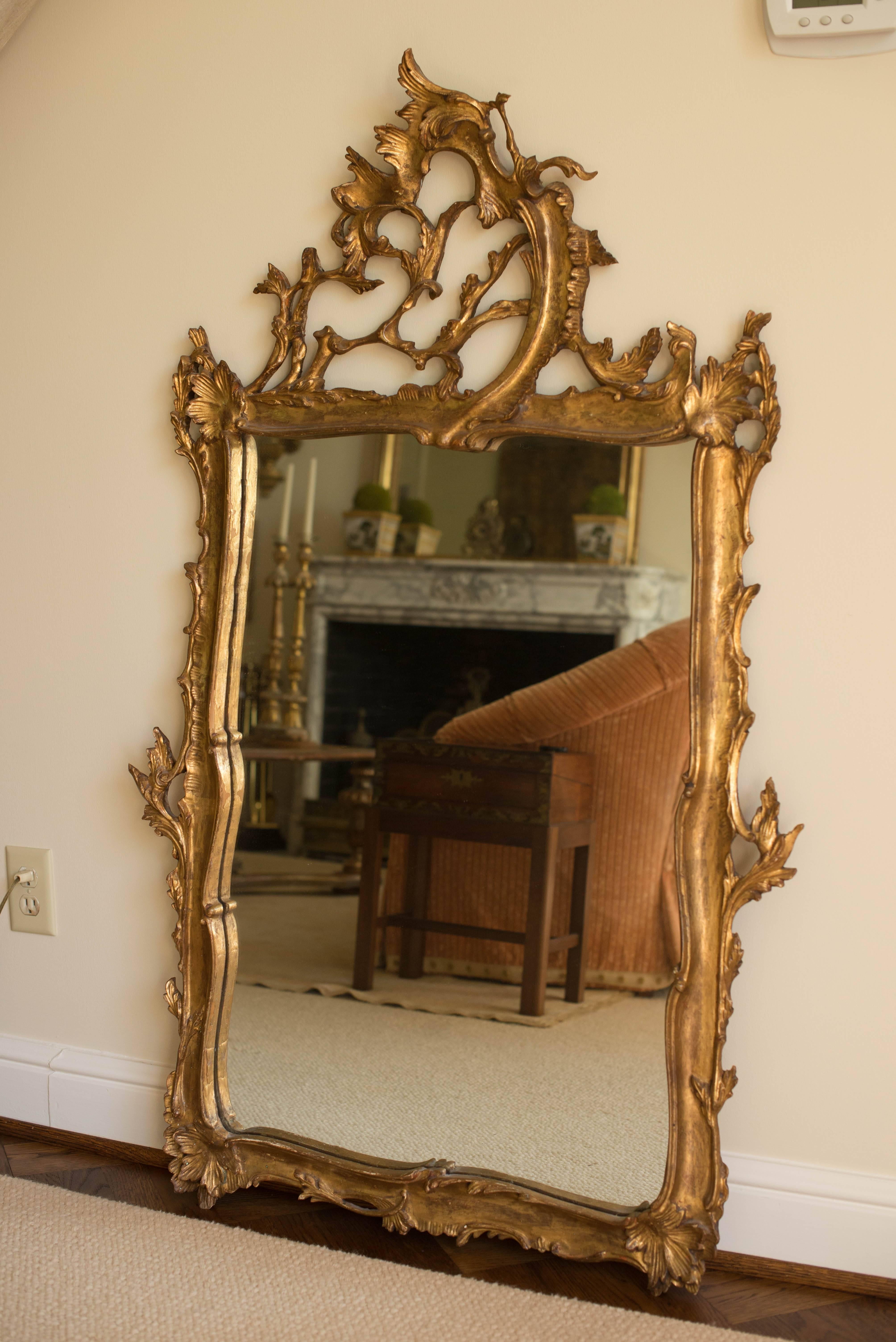 This Italian ornately carved giltwood mirror features a lovely leafy design. It was likely made in the mid-20th century and is in excellent condition.