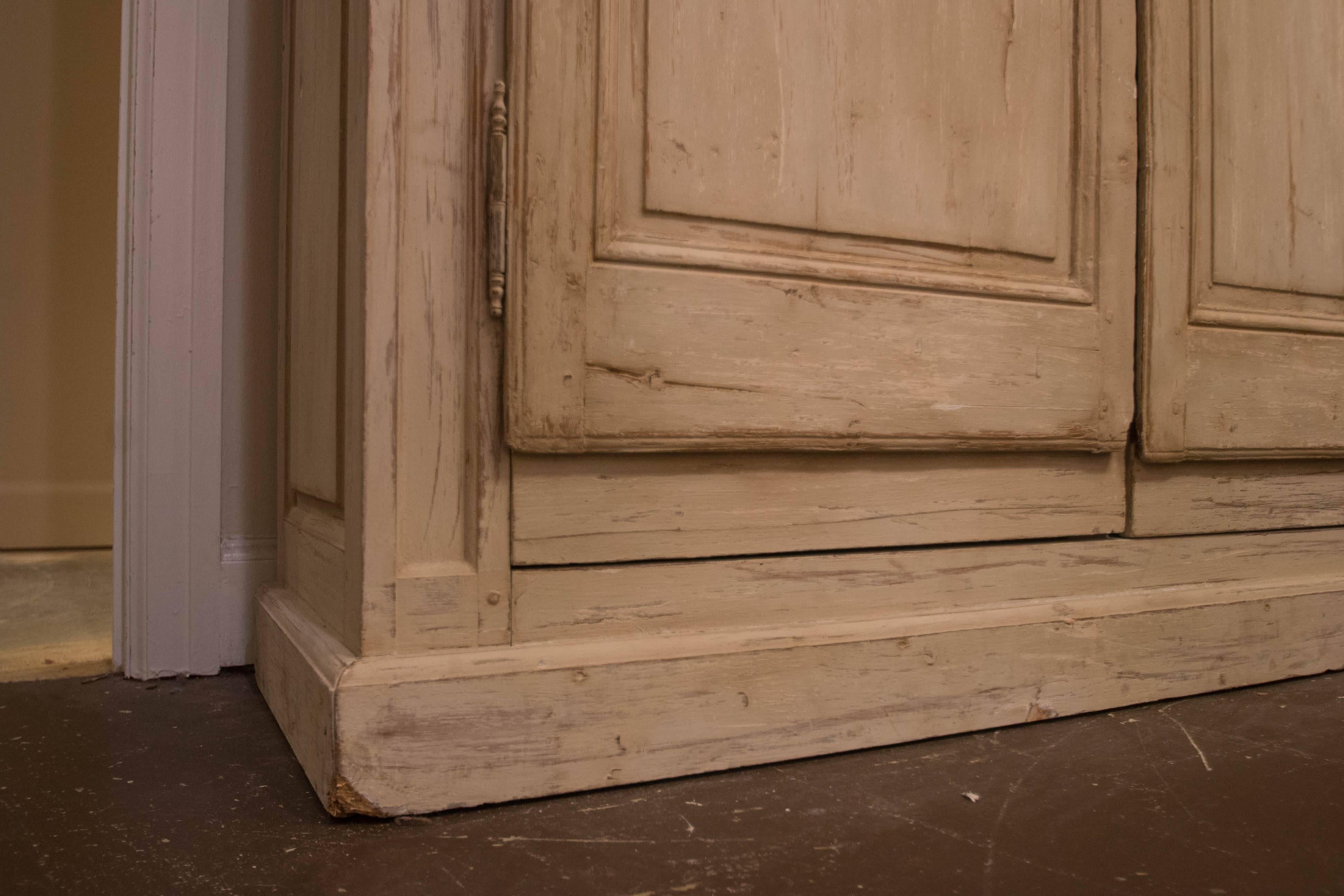 This 19th century French Bibliotheque has a beautiful creamy painted finish on the exterior and is painted red on the interior. Both doors open to reveal three adjustable interior shelves. The raised panel doors have wire mesh in the top panels.