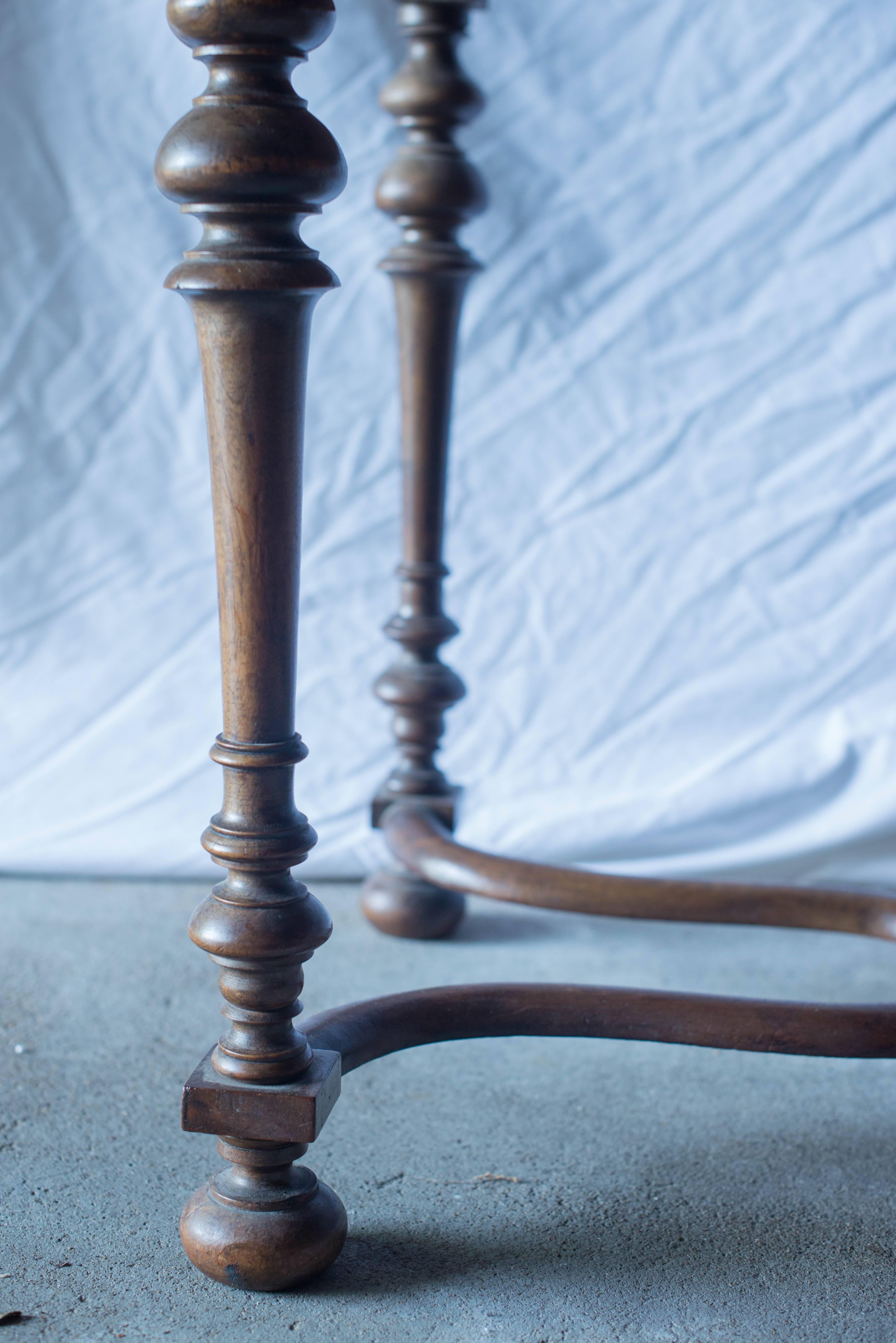 This 19th century French walnut writing or side table features one-drawer with the original hardware. It has a lovely curved stretcher with turned legs.