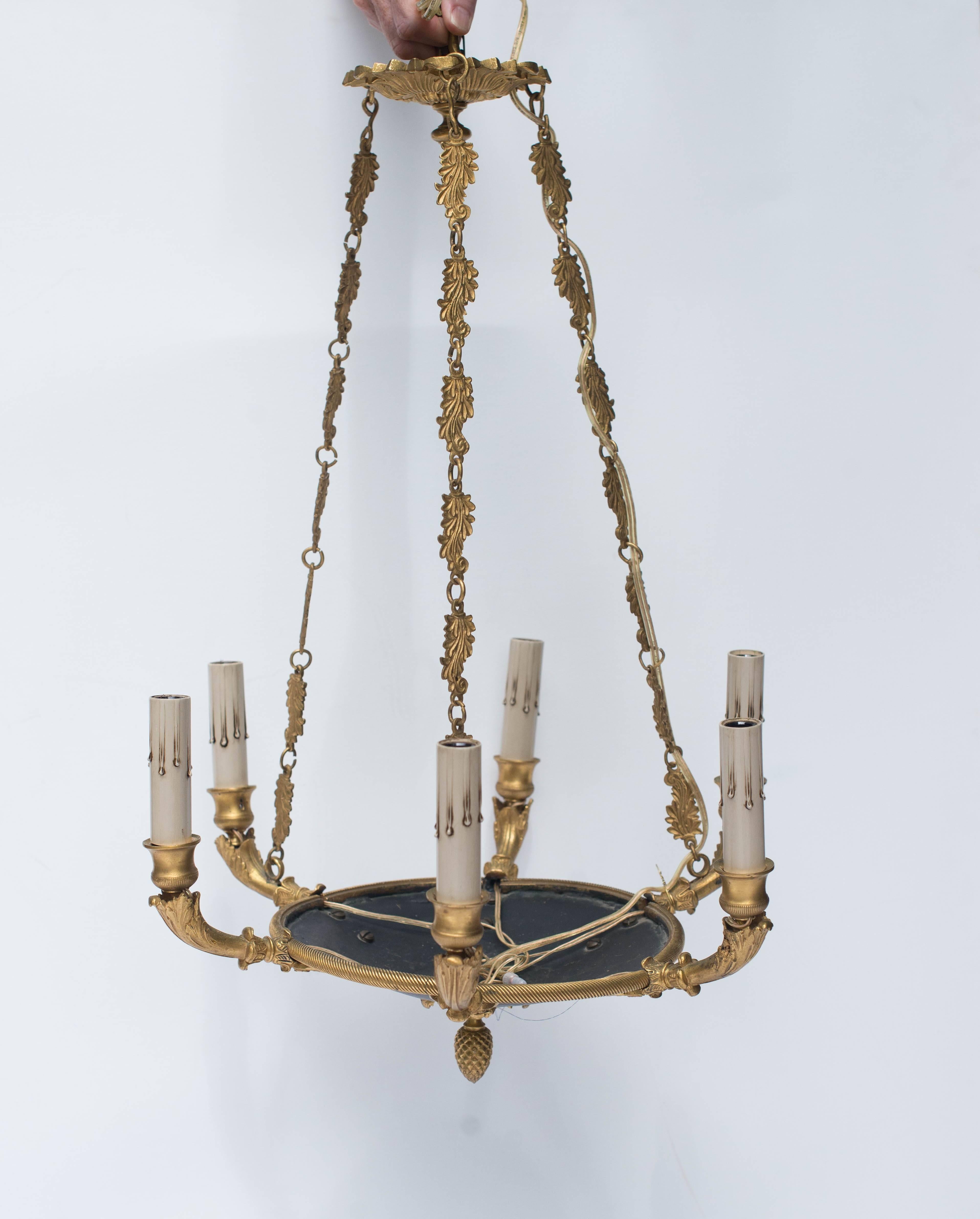 This early 20th century French Empire style chandelier is bronze and features six arms with a black tole bowl. The decorative chain is original ut the chandelier has been newly rewired for American use.