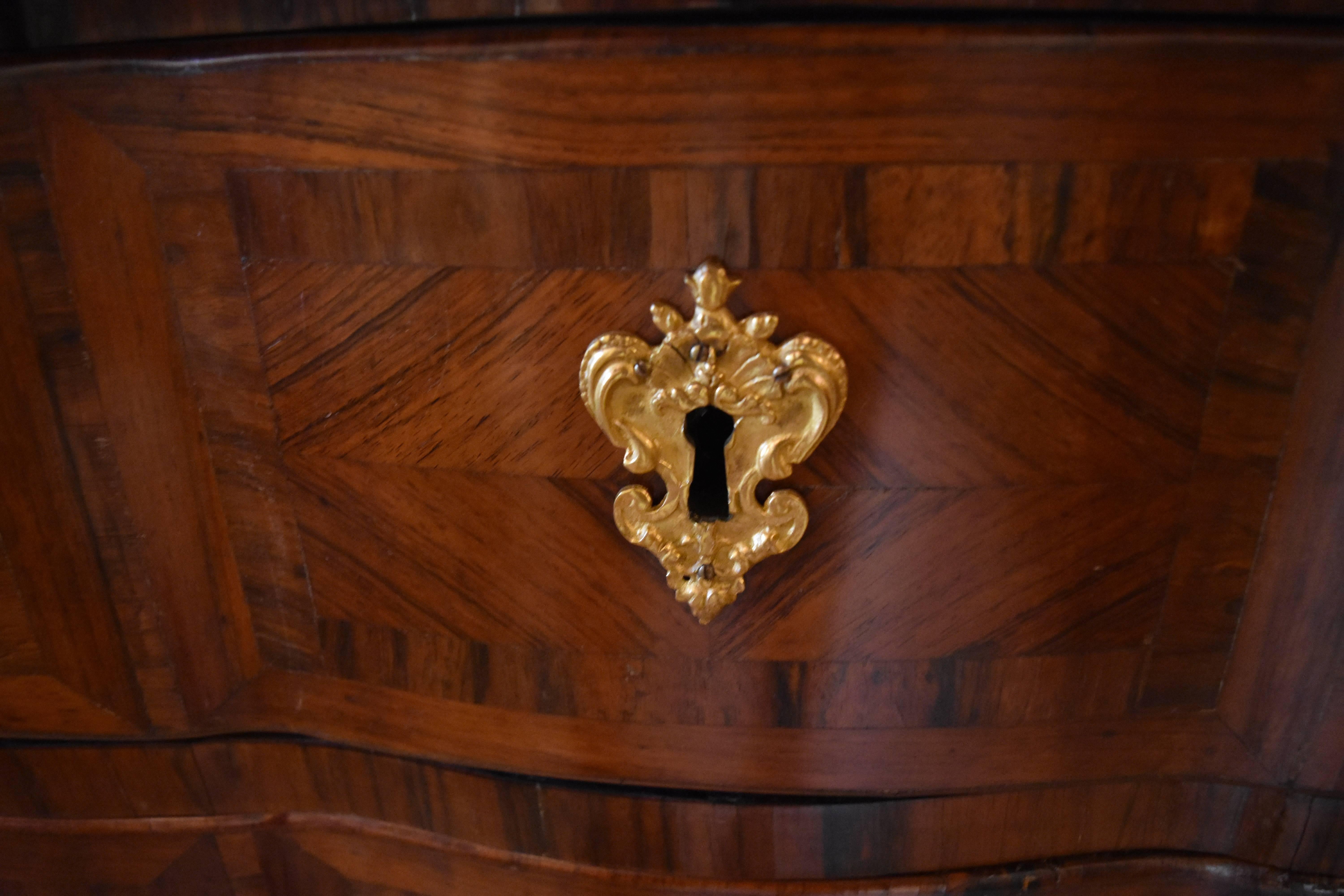 This 18th century commode was purchased from an antique store across the street from the Louvre in Paris. It features exceptional parquetry on all sides with additional parquetry on the drawer tops that can only be viewed when the drawers are open.