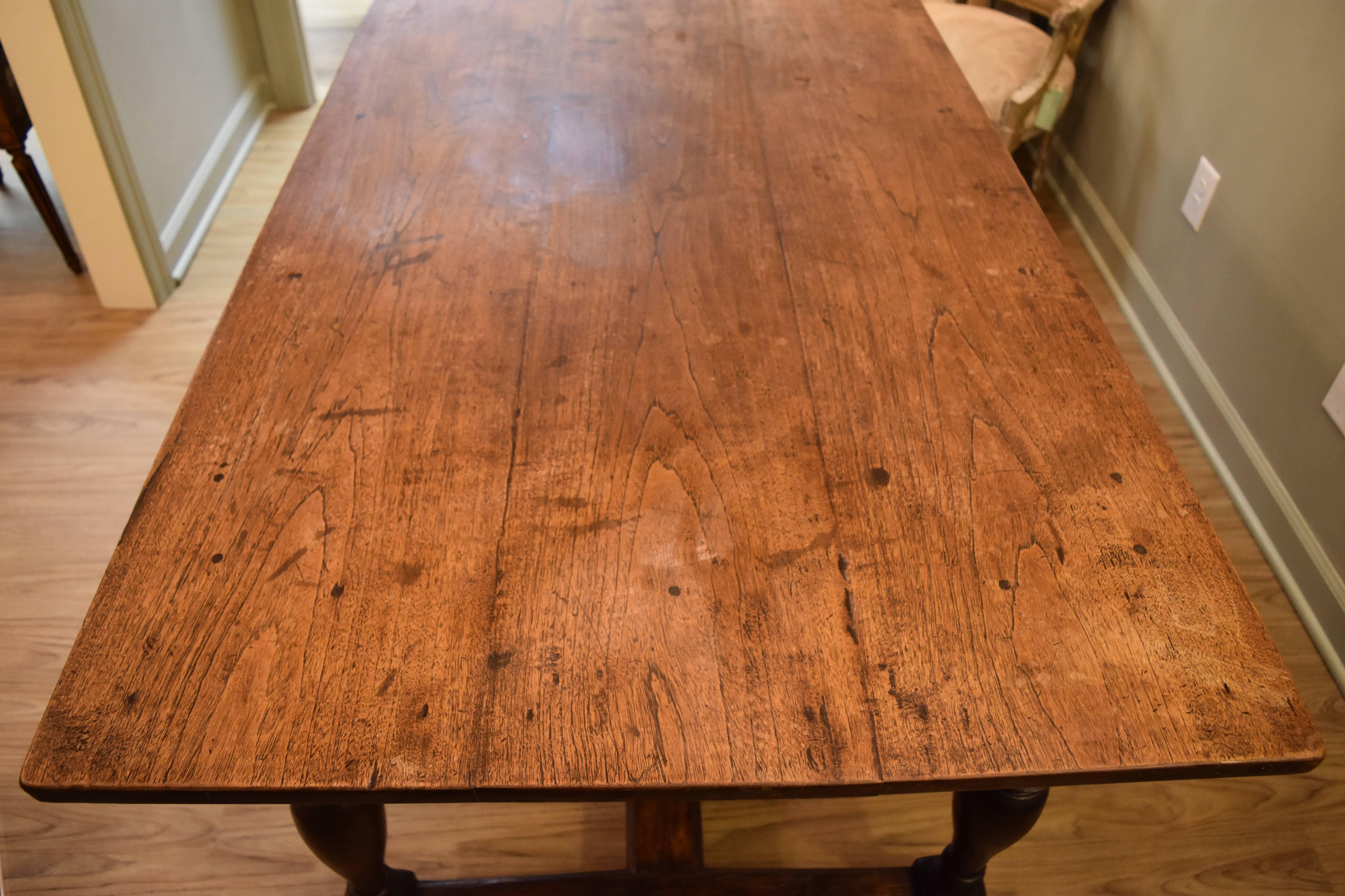 This 19th century French farm table is made of oak and walnut. It is in the trestle style and has a wonderful warm patina.