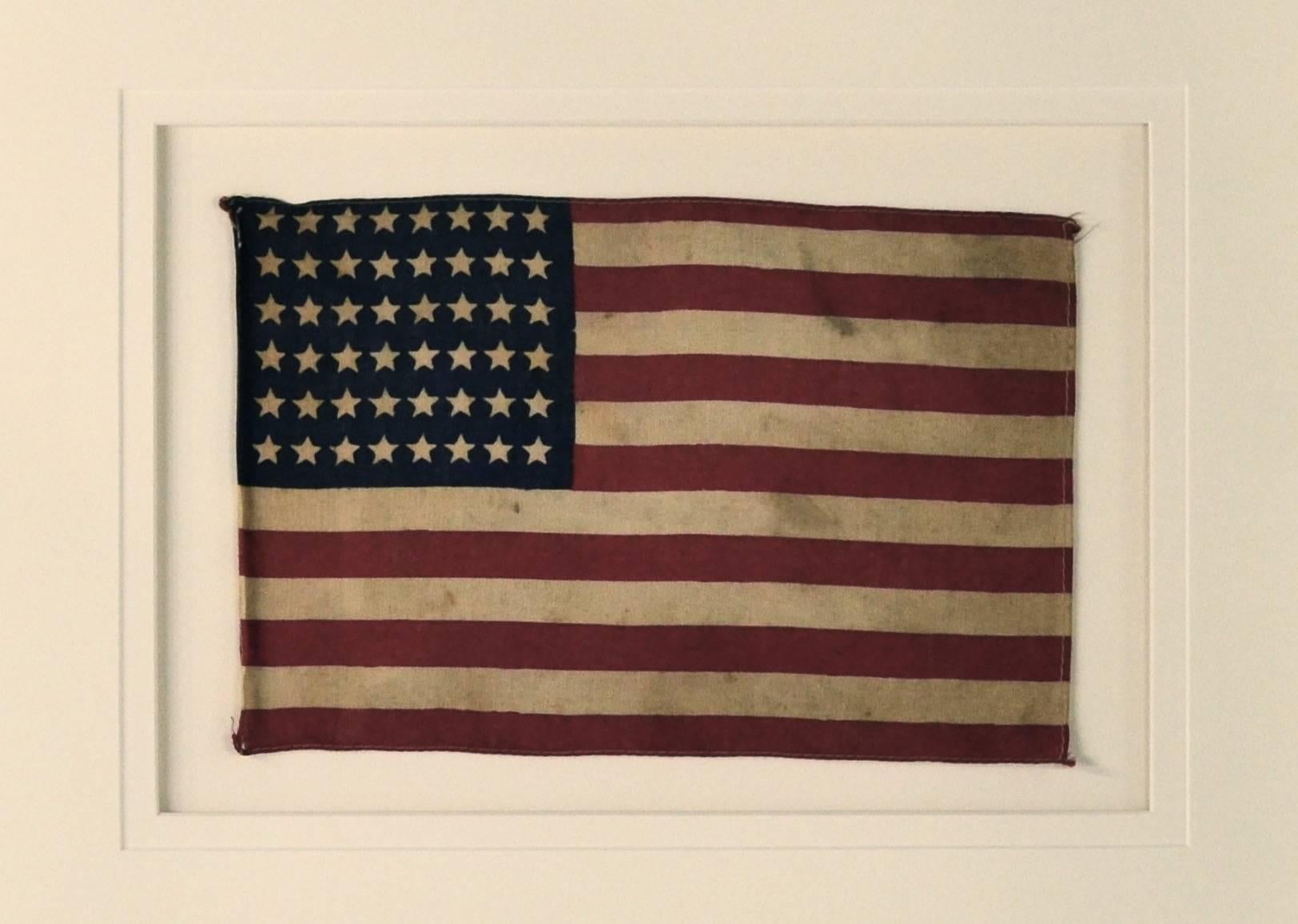 Authentic vintage 48 Star Flag made of printed cotton with sewn edges.
The 48 Star Flag was used from 1912-1959.
Conservation framing with UV acrylic.
 