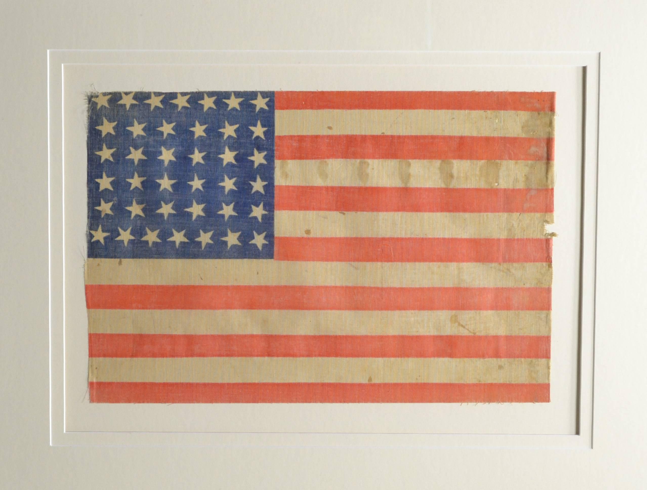 Authentic antique 38 star flag from 1876, America's birthday. Flag has a very rare star arrangement as it is arranged in a square pattern. Some call this a bee hive pattern. Nevertheless it’s a rare star pattern. The stars are tilted and look like