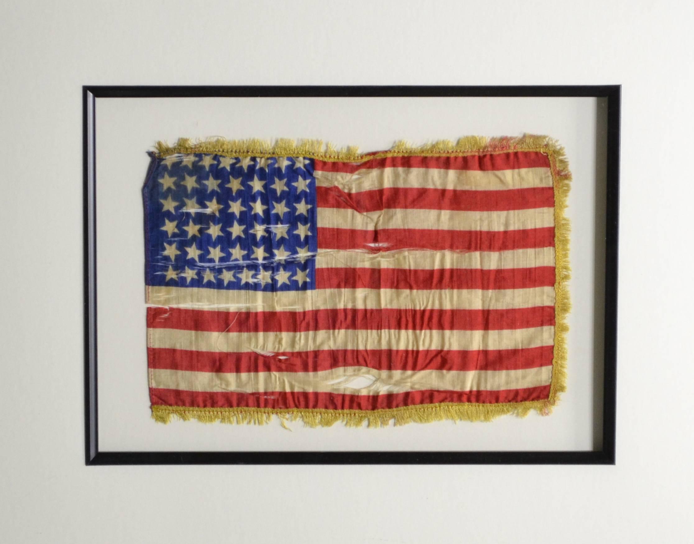 Very unique authentic antique 44 star American flag. Made of silk with fringe sewn attached. The colors are still very strong. The silk has split in several places but the flag has been framed by conservation methods so it’s safe for another100