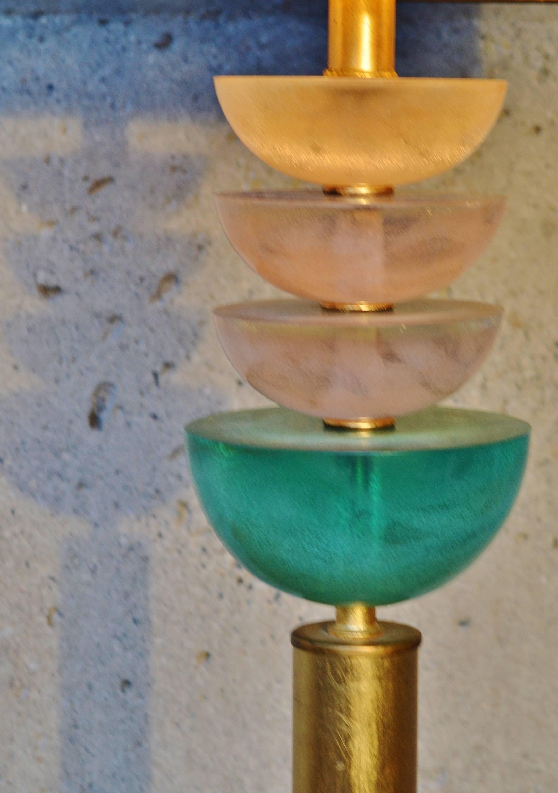This absolutely striking Hollywood Regency lamp is comprised of four stacked lucite half spheres with one gold, two rose quartz and the larger, lowest one in turquoise.  Gold leaf gilt cubic base and cylinder stem with brass rings between each