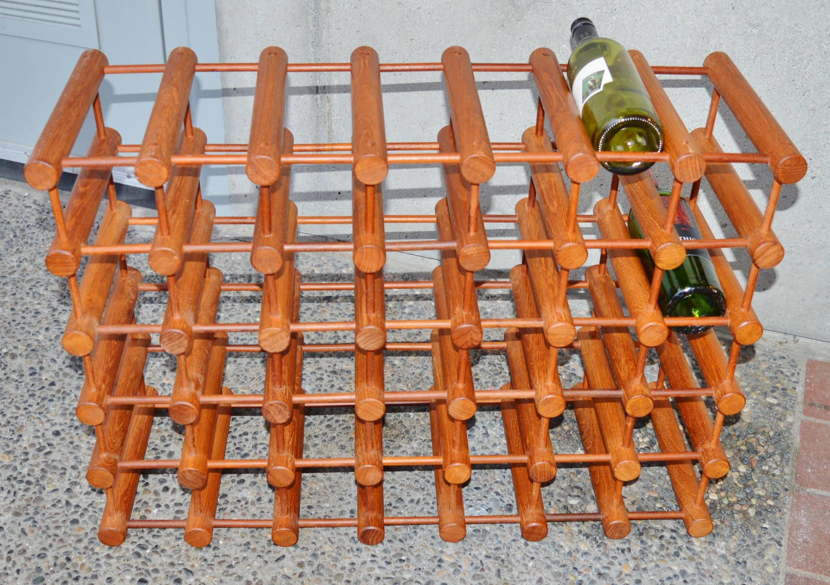 This amazing modular Danish Modern teak wine rack was designed by Richard Nissen and is cleverly comprised of teak cylinders in two dimensions. Spaced perfectly, so a wine bottle rests on the top of the cylinders while the neck is supported by the